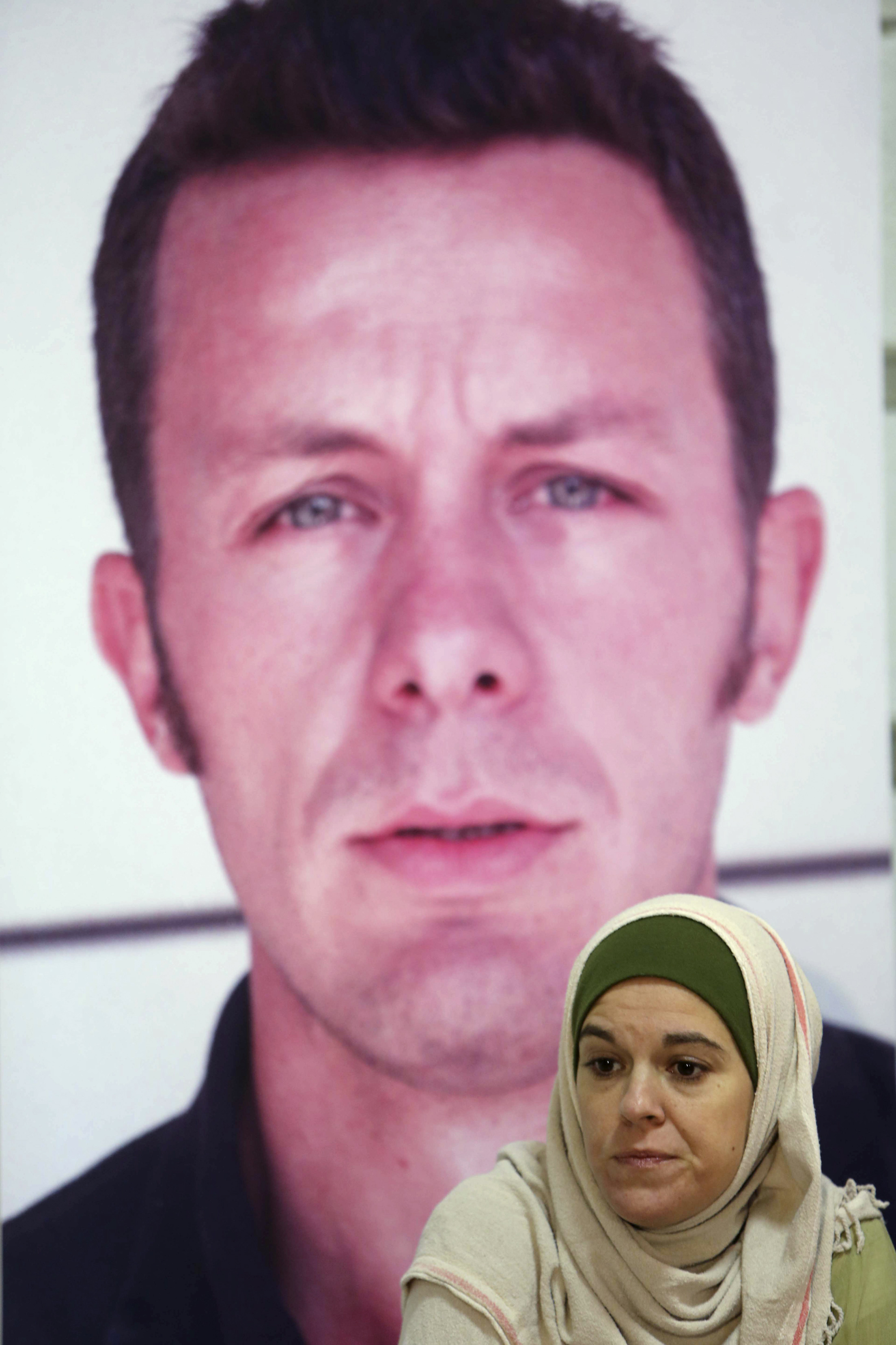 Monica G. Prieto, wife of Spanish journalist Javier Espinosa, sits in front of his image during a news conference in Beirut on 10 December