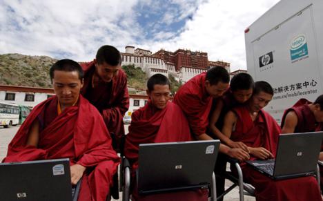 Sur cette photo publiée par l'agence Chinoise d'informations Xinhua, des prêtres tibétains essayent des ordinateurs portables sur la place devant le Palais du Potala en plein Lhassa, capitale de la région autonome du Tibet dans le sud-ouest de la Chine