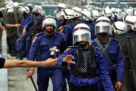 Un manifestant pacifique offre une fleur à un officier de police lors d’une manifestation survenue le 13 mars 2011 à Bahreïn