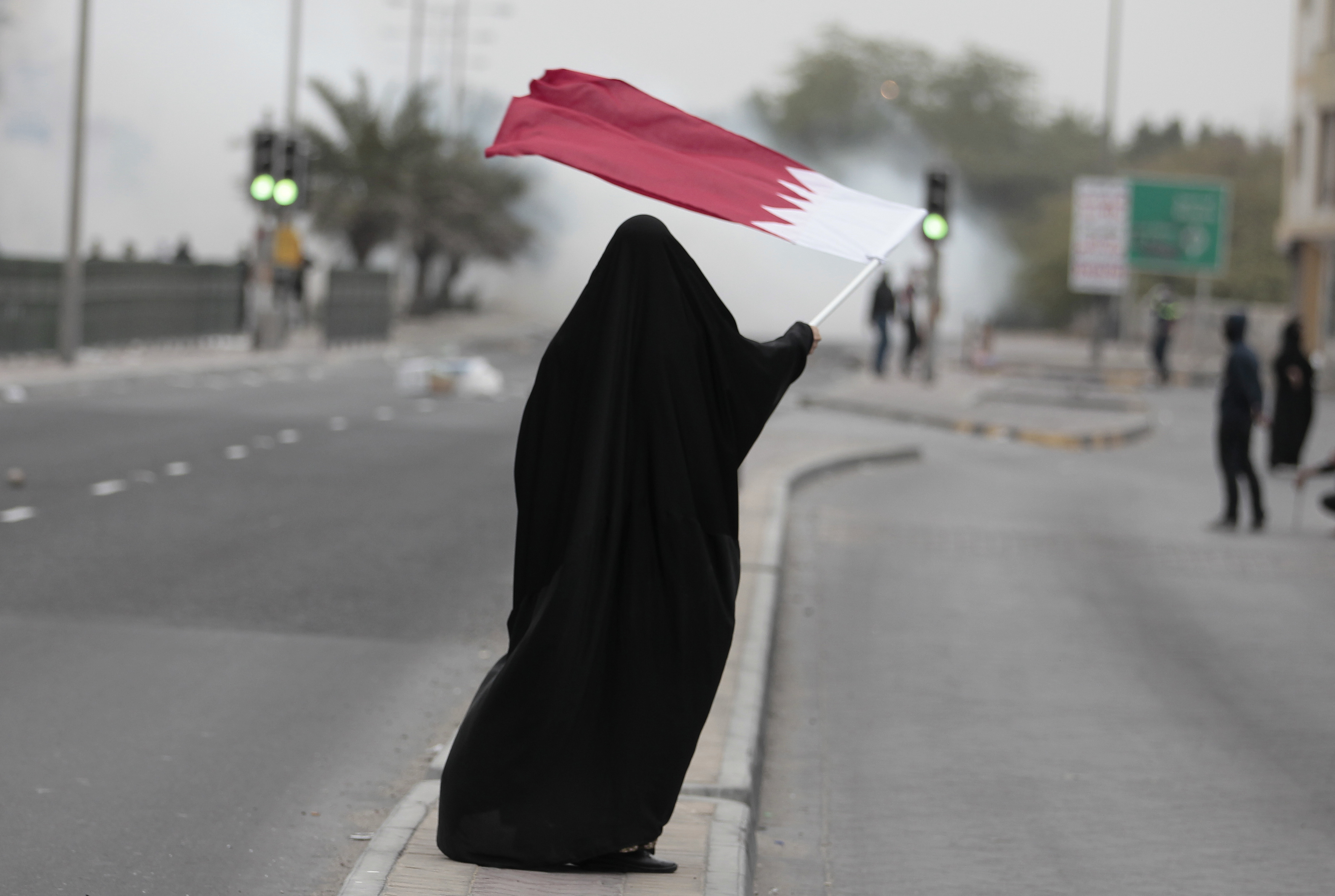 A female protester waves Bahrain's flag as she takes part in a protest marking the 4th anniversary of the 14th February uprising to demand democratic reforms in the village of Sanabis, west of Manama, February 14, 2015