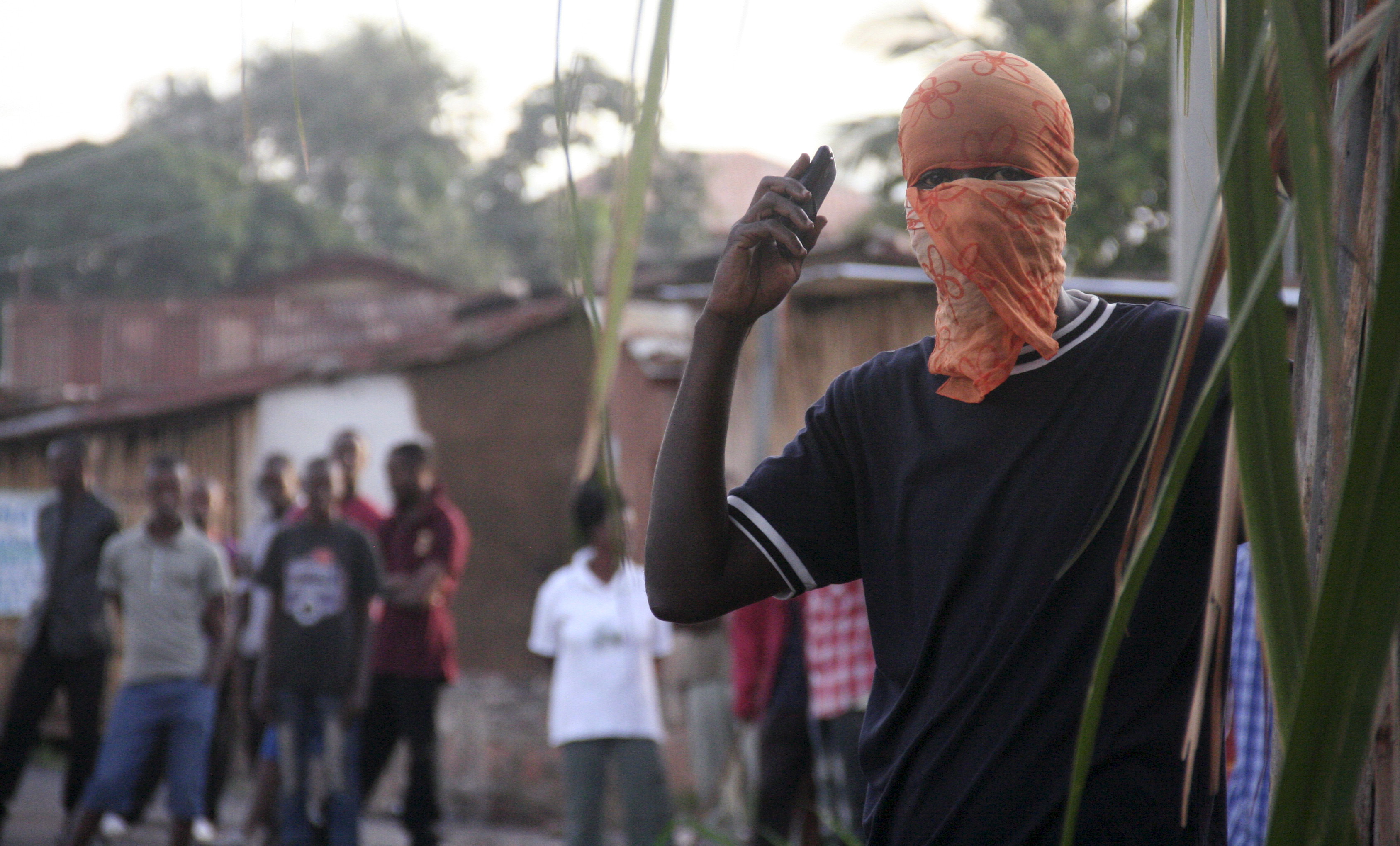 A masked protester listens to the radio during demonstrations against the ruling CNDD-FDD party's decision to allow Burundian President Pierre Nkurunziza to run for a third five-year term in office, in Bujumbura, 4 May 2015