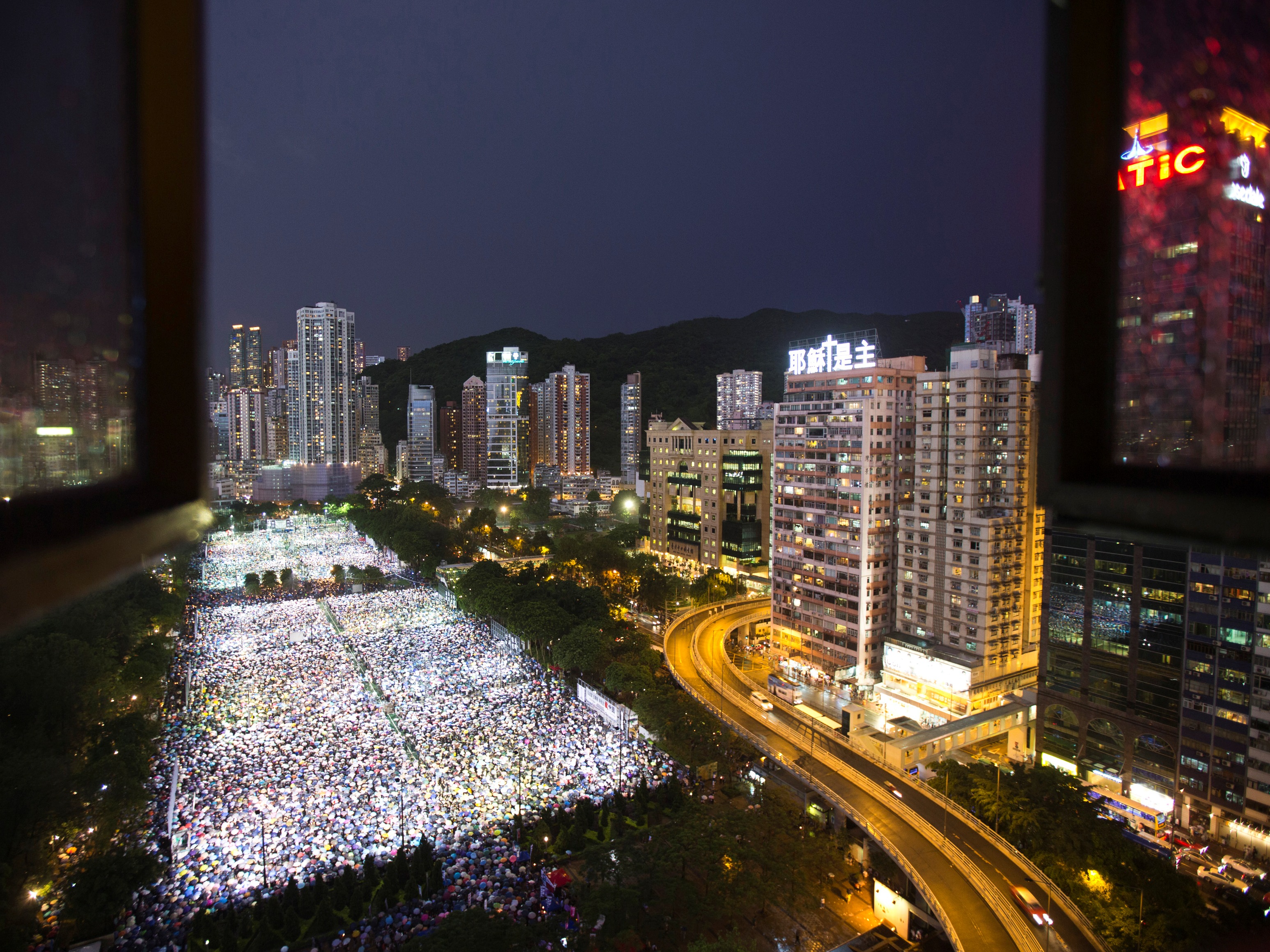 Tens of thousands of people participate in a candlelight vigil in Hong Kong to mark the 24th anniversary of the 1989 crackdown on the pro-democracy movement in Beijing