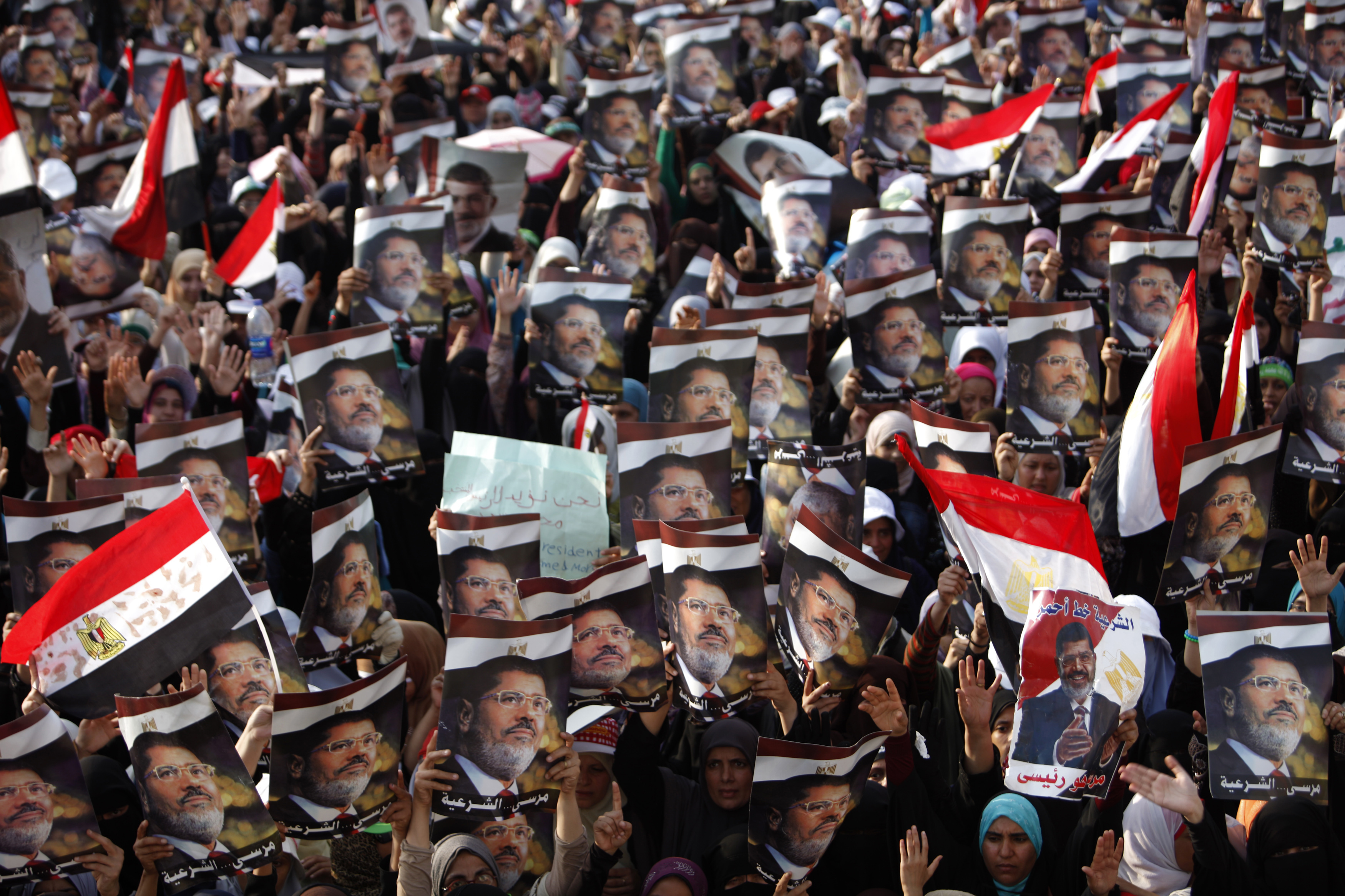 Partidarios de Morsi sostienen sus carteles en una manifestación en la plaza Rabaa Adawia, donde están acampando en El Cairo el 08 de julio 2013