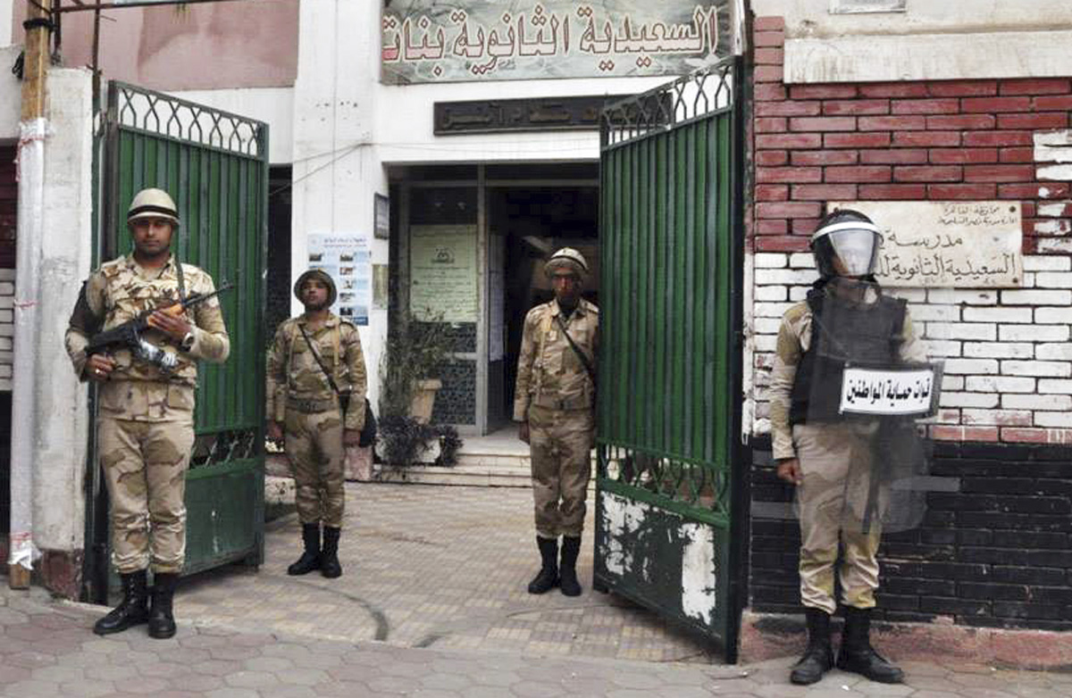 -	الجنود المصريون يحرسون في باحة المدرسة التي ستستخدم كمركز للاقتراع في وسط القاهرة بتاريخ 13 كانون الثاني 2014