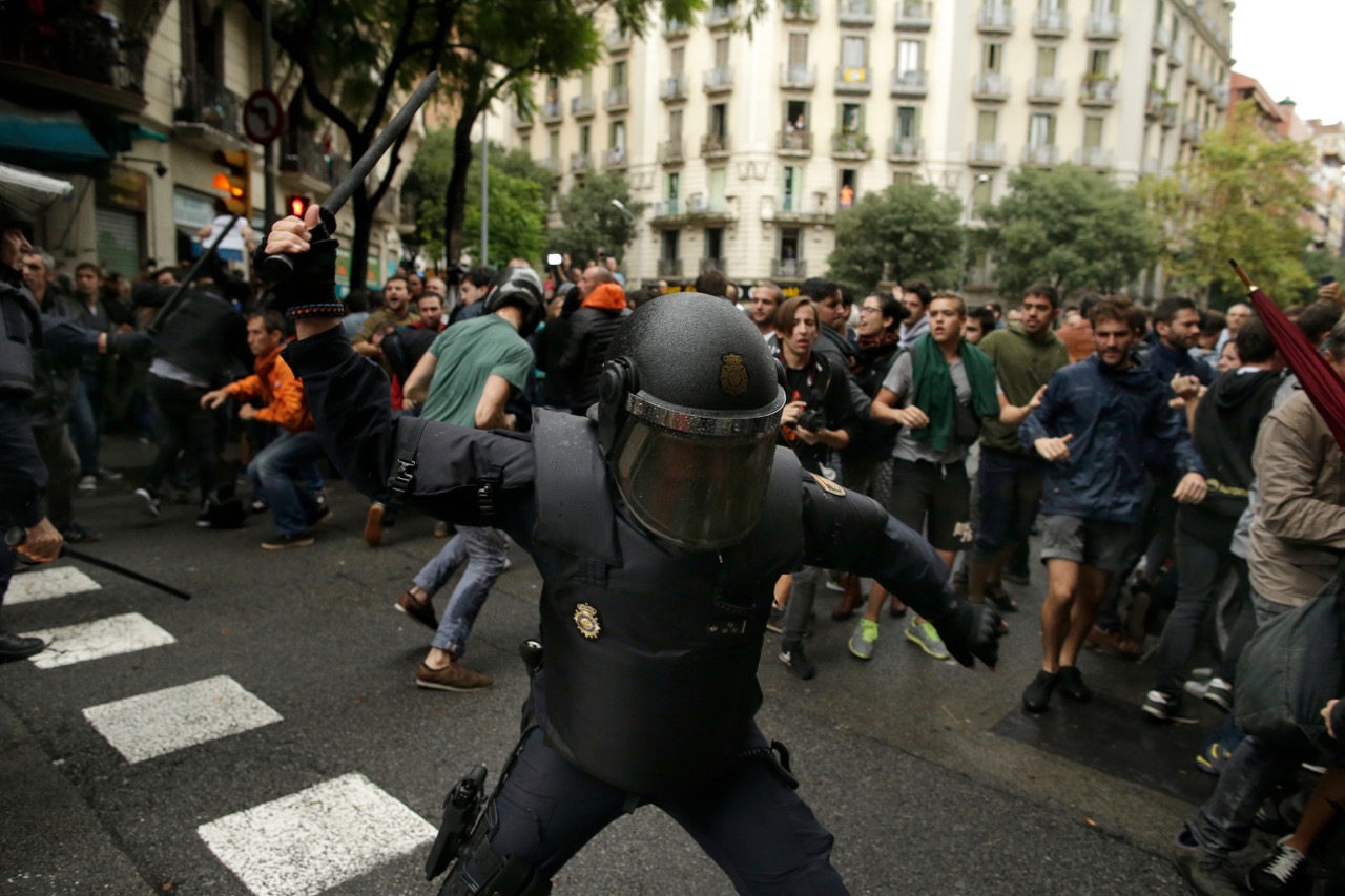 Barcelone, Espagne, le 1er octobre 2017. Un policier anti-émeute espagnol balance une matraque vers les éventuels électeurs près d'une école assignée à un bureau de vote