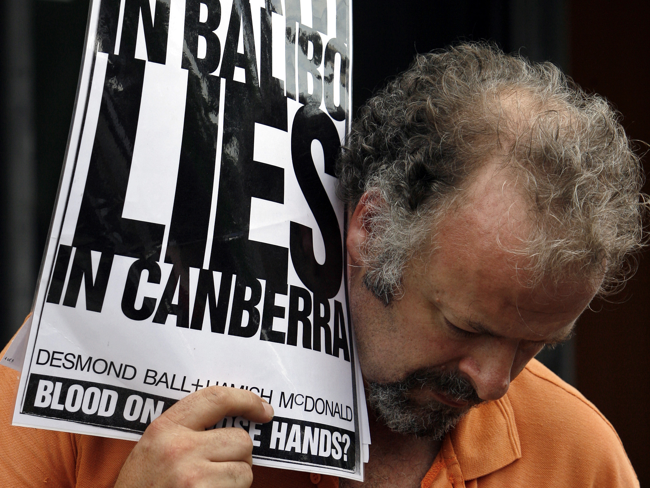 In this 8 May 2007 file photo, a protester holds a placard outside the Glebe Coroner's Court in Sydney during the inquest into Brian Peters' death