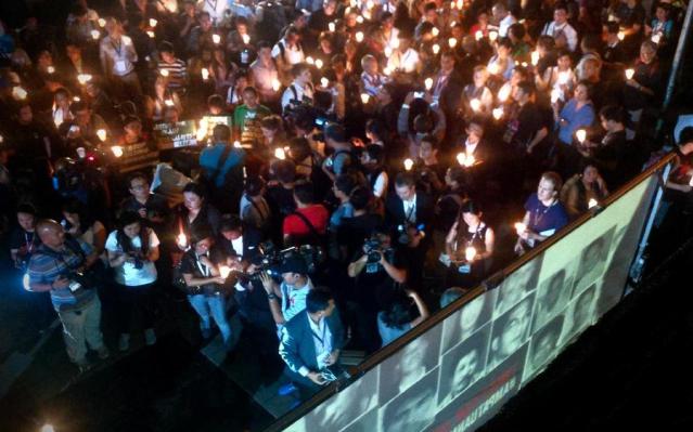 Des gens et des médias ont assisté à la veille aux chandelles au sanctuaire EDSA de Quezon City, à Manille, le 23 novembre 2014