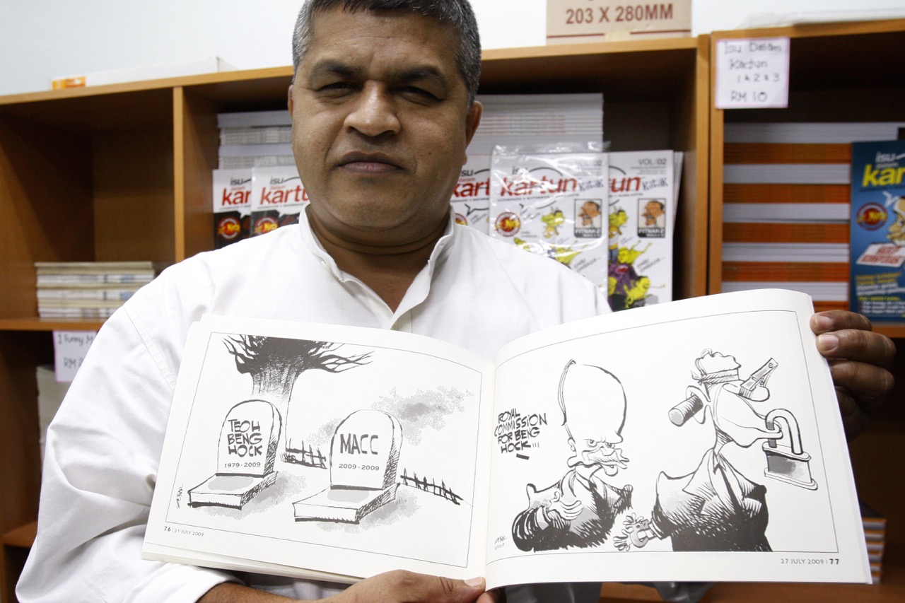 Malaysian cartoonist Zunar holds a copy of his comic book that was banned by the Malaysian Home Ministry in Kuala Lumpur, 25 June 2010