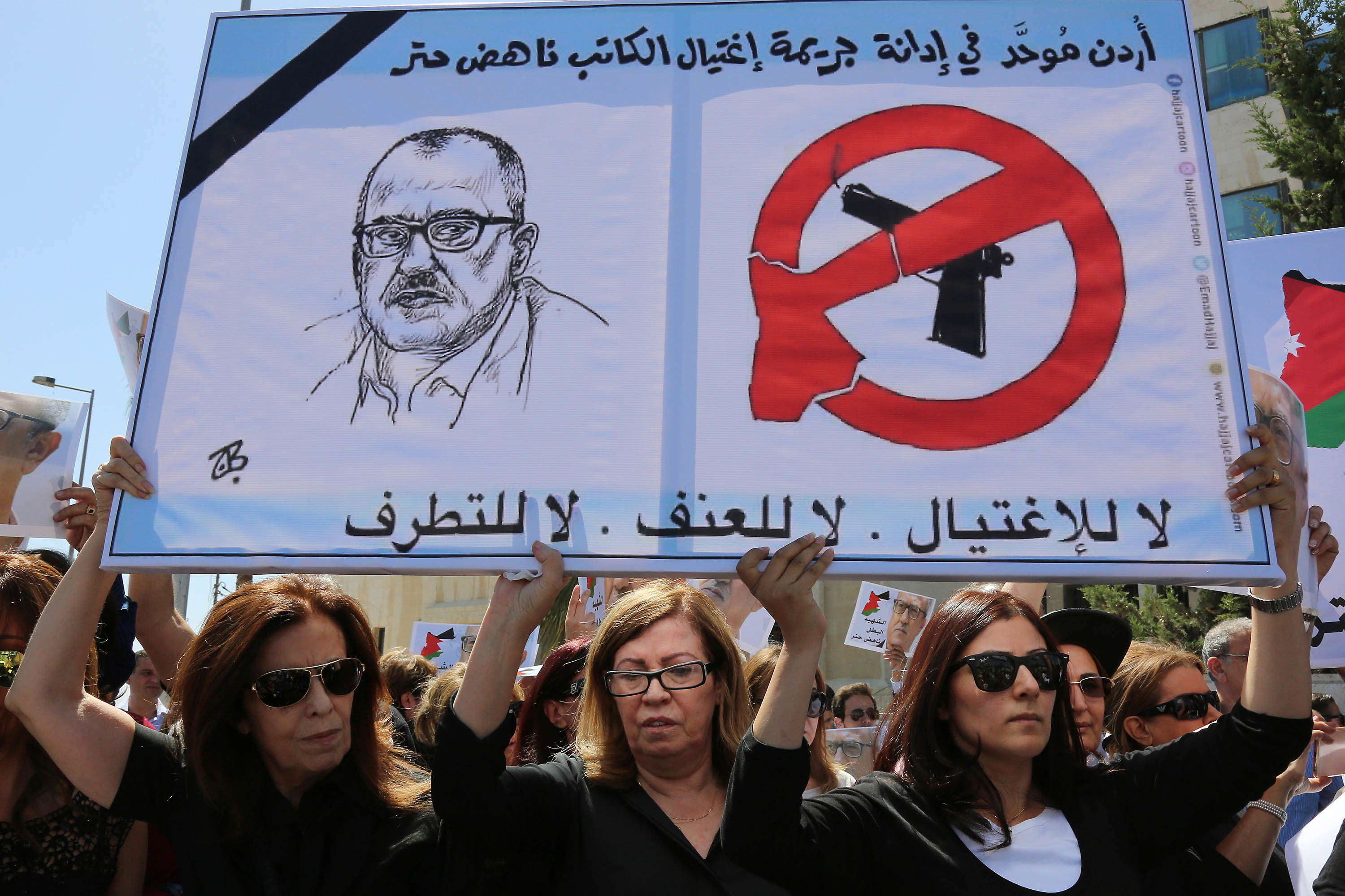 Relatives of Jordanian writer Nahed Hattar protest in front of the Jordanian Prime Ministry in Amman, Jordan over Hattar's death. Sign reads in Arabic: No to assassination, no to violence, no to extremism