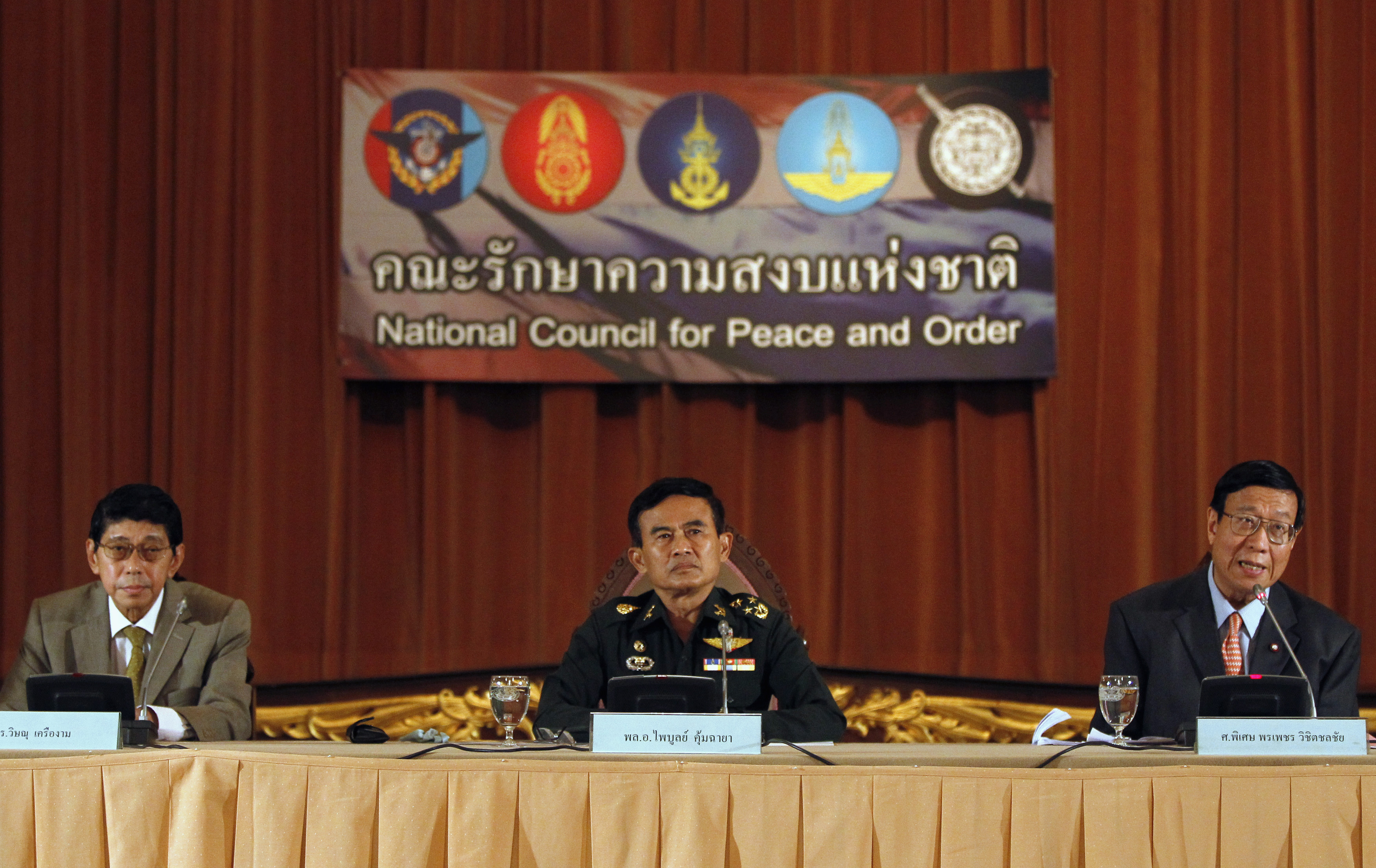 Thailand's Deputy National Council for Peace and Order (NCPO) chief General Paiboon Koomchaya (C), NCPO legal adviser Wissanu Krea-ngam (L) and Pornphet Vichitcholchai, Chief Counsel of the National Peace Keeping Council, attend a news conference on the details of the interim charter, at the Government House in Bangkok, 23 July 2014