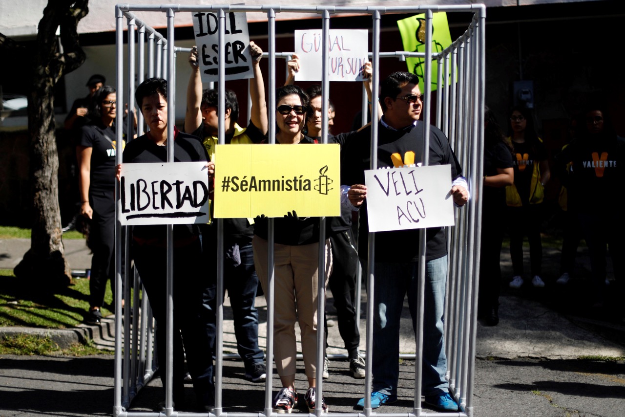 Members of Amnesty International are seen inside a mock prison cell during a demonstration demanding the release of activists arrested in Turkey, outside the Turkish Embassy in Mexico City, 31 July 2017