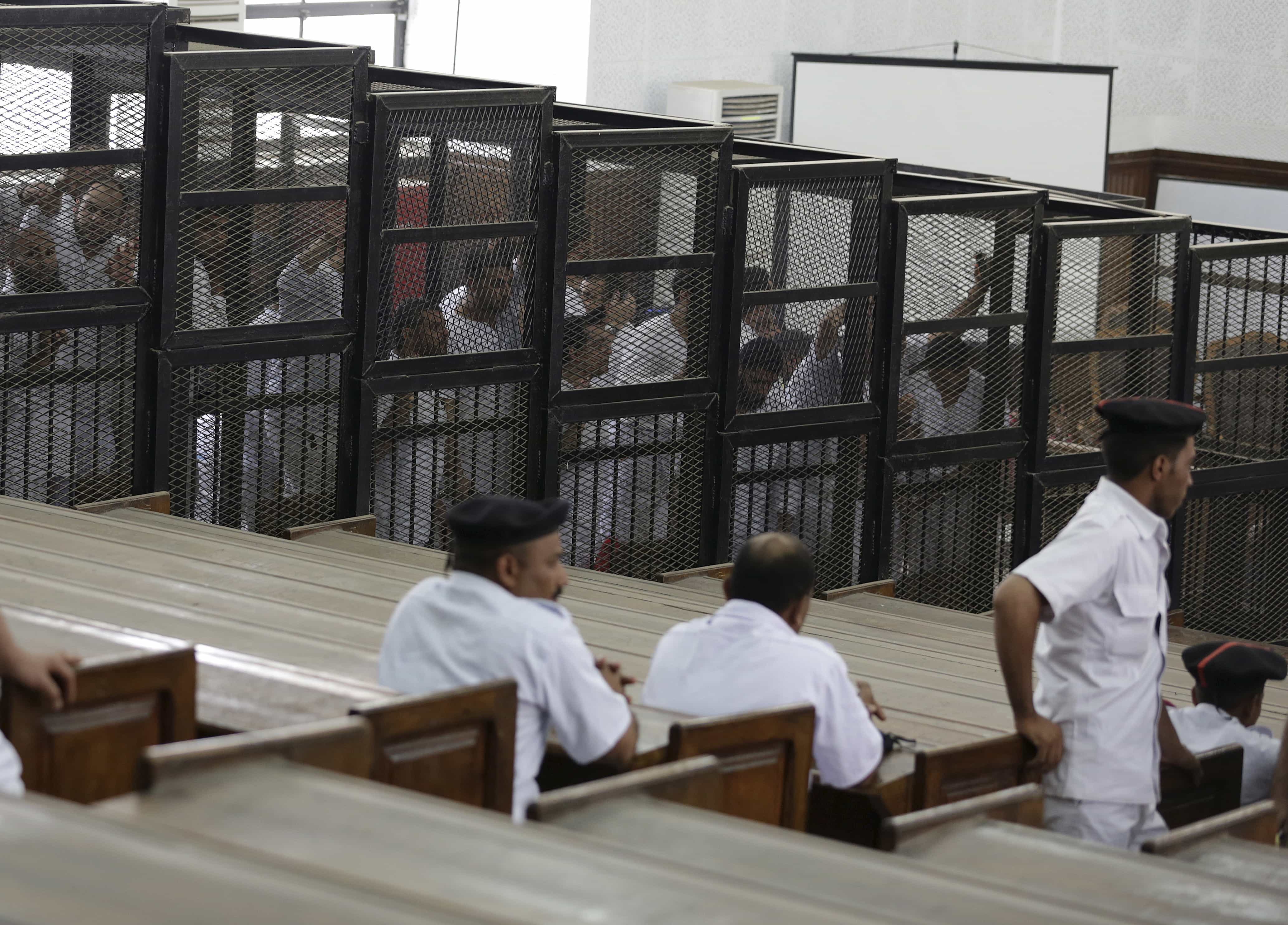 Suhayb Saad, an activist who rights groups say was taken by security forces and forced to confess on TV his membership of a terrorist cell, stands behind bars with other co-defendants as they wait for the ruling at a court in Cairo June 23, 2014, REUTERS/Asmaa Waguih