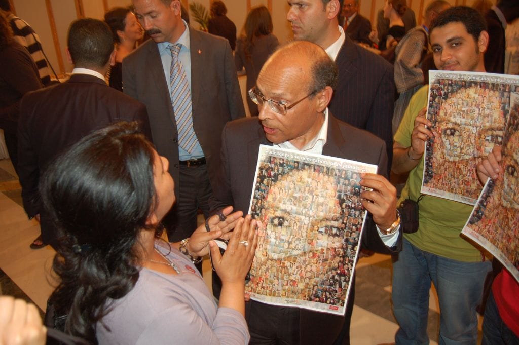 Tunisian President Moncef Marzouki holds an IFEX-Tunisian Monitoring Group/Nawaat.org poster at World Press Freedom Day celebrations in May 2012., Nawaat.org