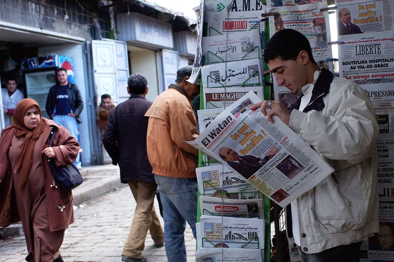A man reads a copy of "El Watan" at a newspaper stand in Algiers, 28 November 2005. "El Watan" has been denied state advertising since the 1990s, AP Photo/Ouahab Hebbat