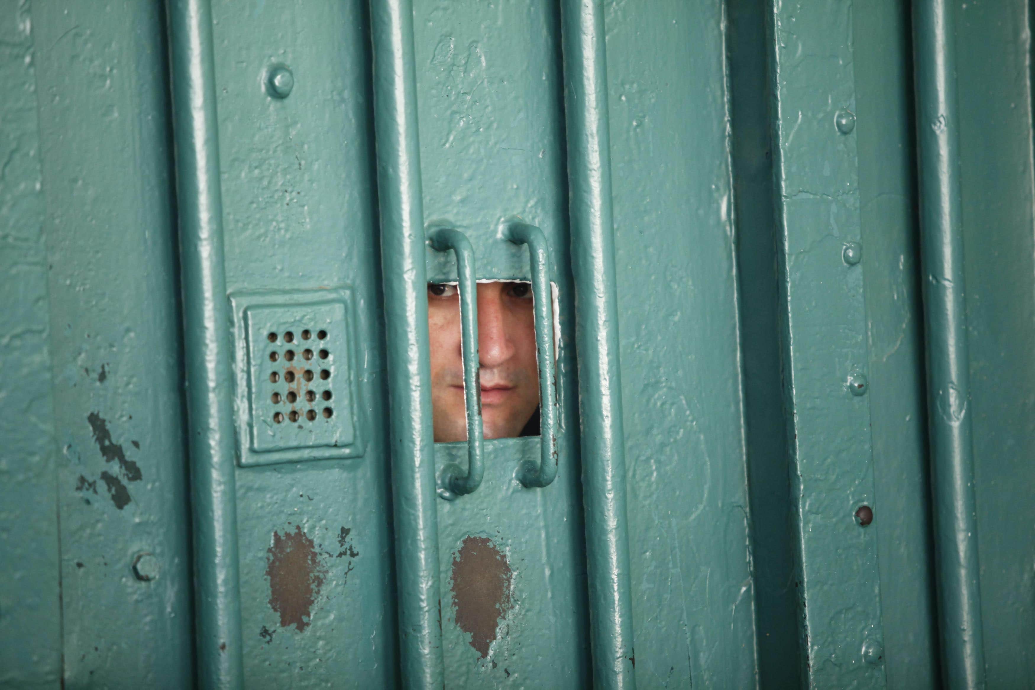 A prison guard looks through a small window at the El Harrach prison in Algiers July 14, 2010, ALGERIA-PRISONS/ REUTERS/Louafi Larbi