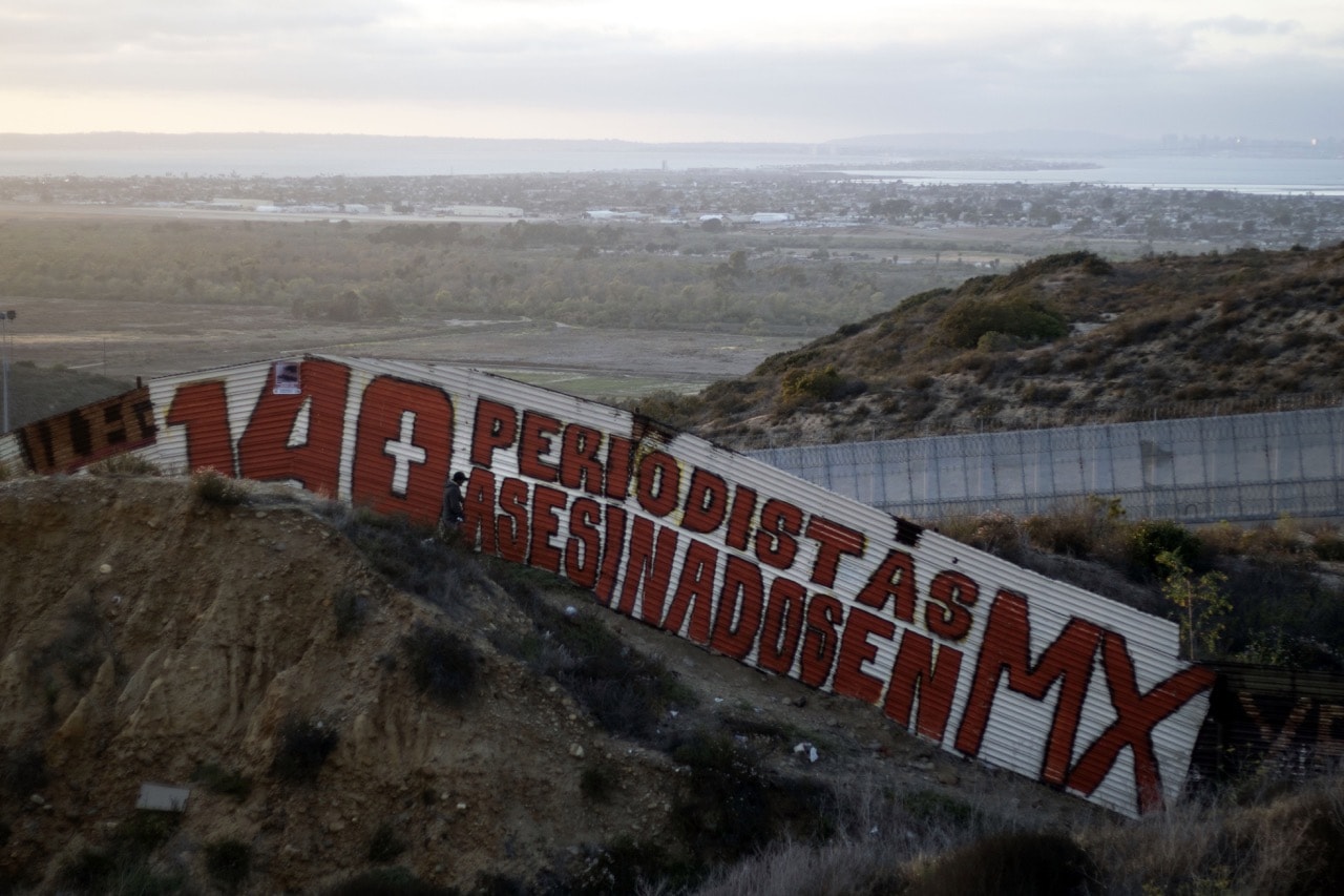 A sign in Spanish saying "140 journalists murdered in MX" is seen on a section of the US/Mexico border fence in Tijuana, Baja California State, Mexico, 14 May 2018, GUILLERMO ARIAS/AFP/Getty Images