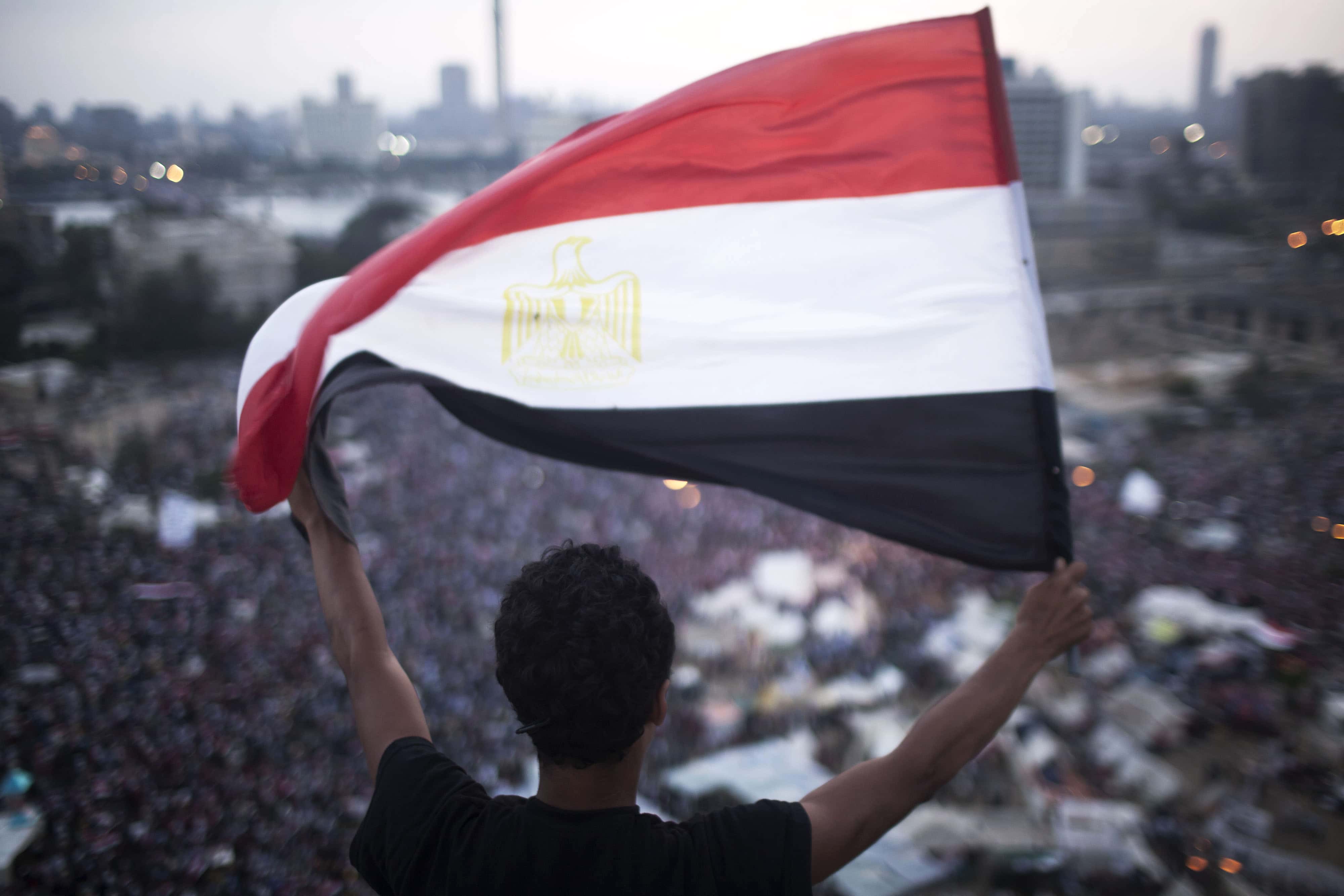 An Egyptian protester waves a flag in Tahrir square on 1 July 2013, AP Photo/Manu Brabo