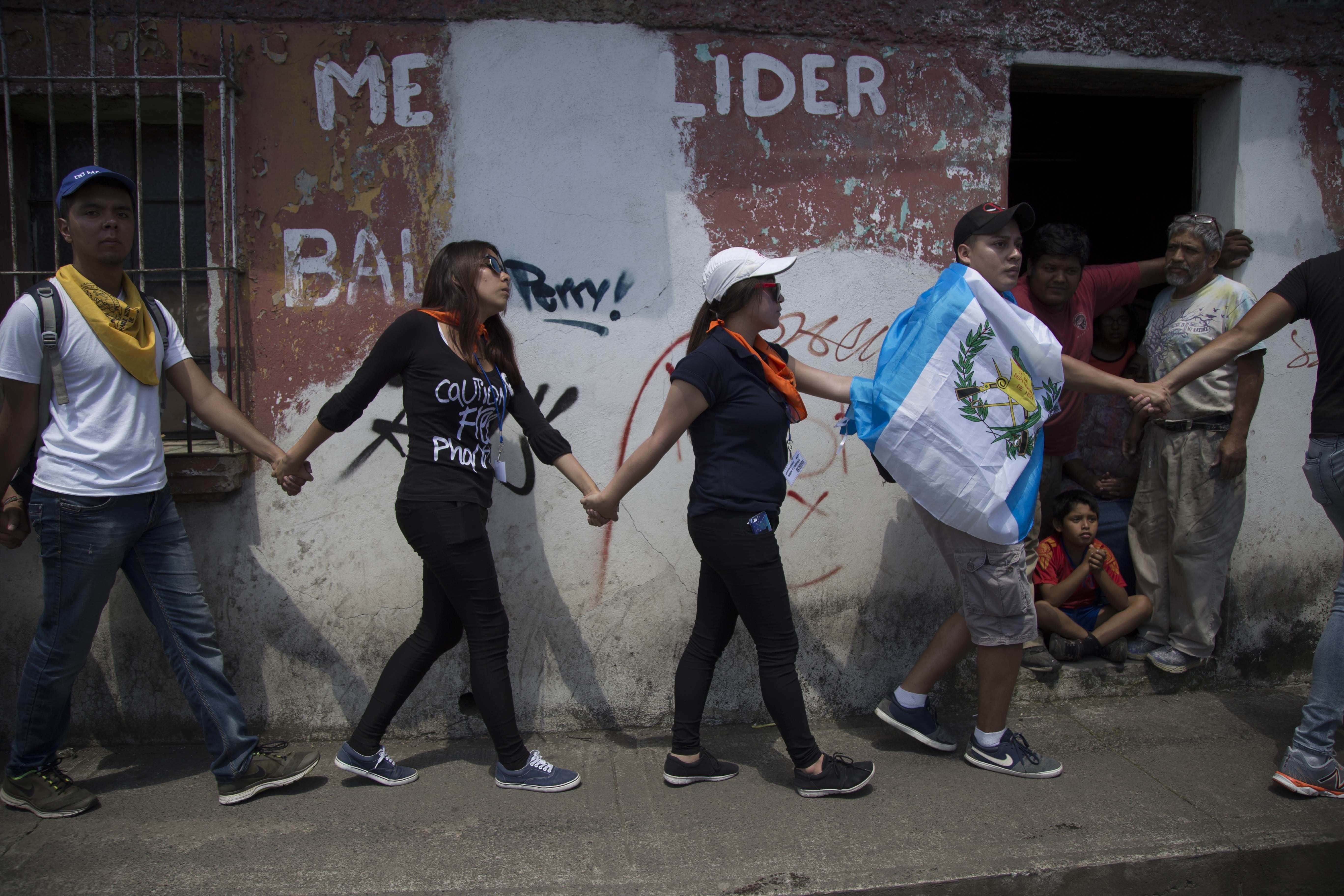 Guatemalan University students walk hand-in-hand demanding the resignation of Guatemalan President Jimmy Morales in Guatemala City, AP Photo/Luis Soto