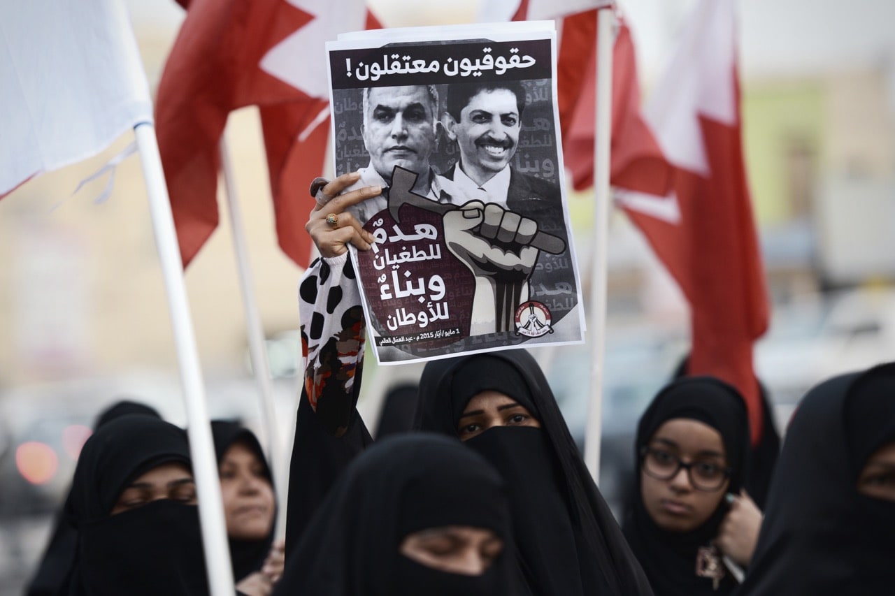 Members of the February 14 Revolution Youth Coalition group hold up a poster bearing portraits of jailed activists Nabeel Rajab (L) and Abdul Hadi Al-Khawaja during a demonstration marking May Day, in the village of Musalla, Bahrain, 1 May 2015, MOHAMMED AL-SHAIKH/AFP/Getty Images