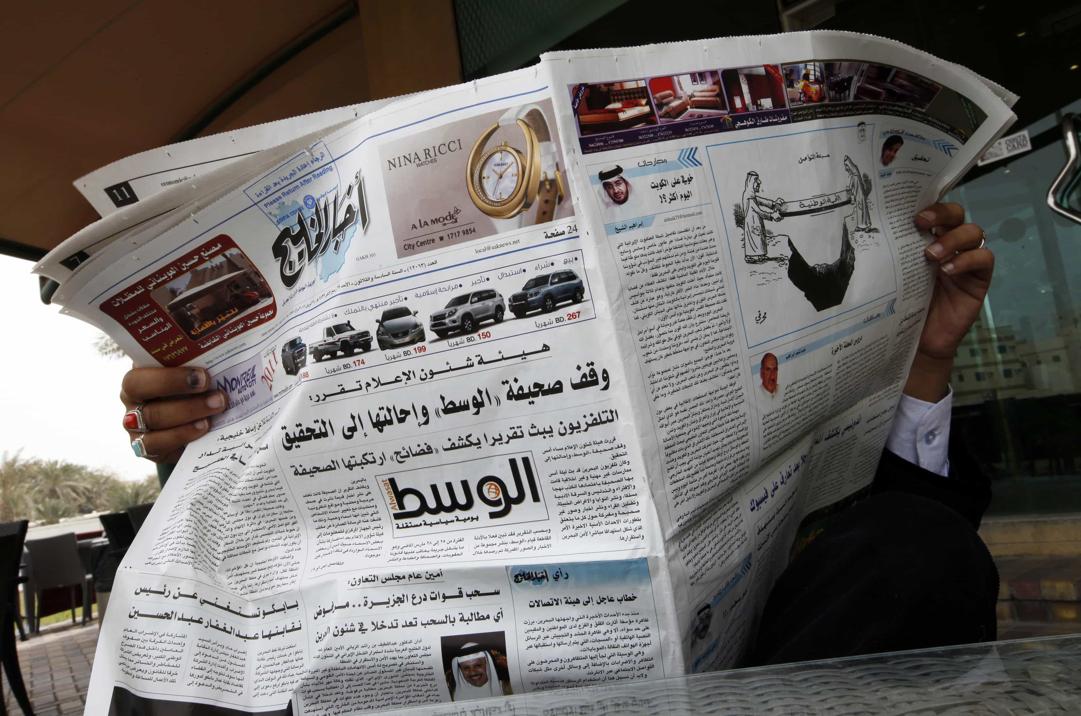 A man reads a newspaper with a headline stating that Bahrain has suspended the newspaper "Al-Wasat" in Manama, 3 April 2011, REUTERS/Hamad I Mohammed