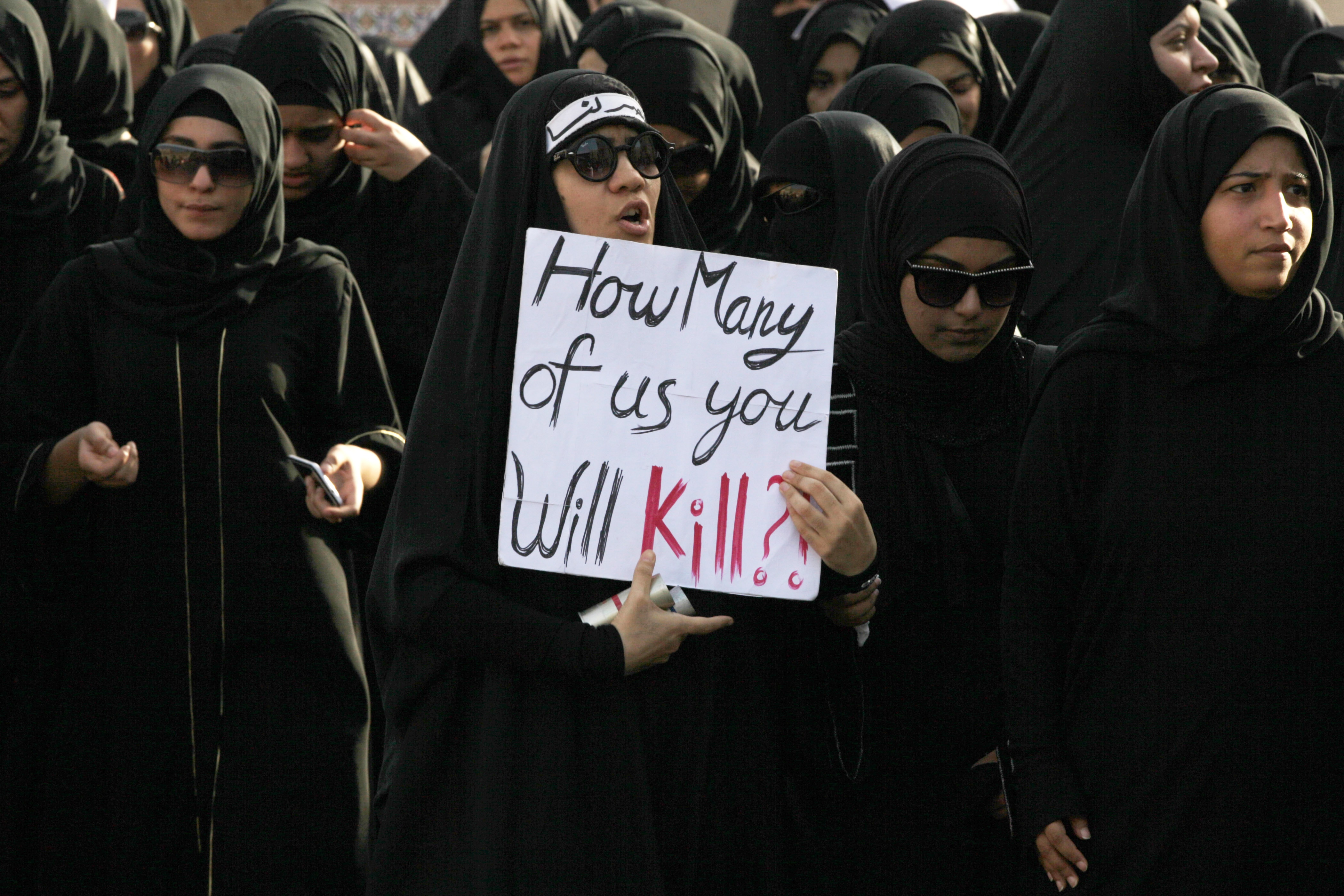 Bahraini mourners carry signs and chant anti-government slogans during the funeral for a protester in Sanabis in the suburbs of the capital of Manama, Bahrain, Sunday, July 6, 2014., AP Photo/Hasan Jamali
