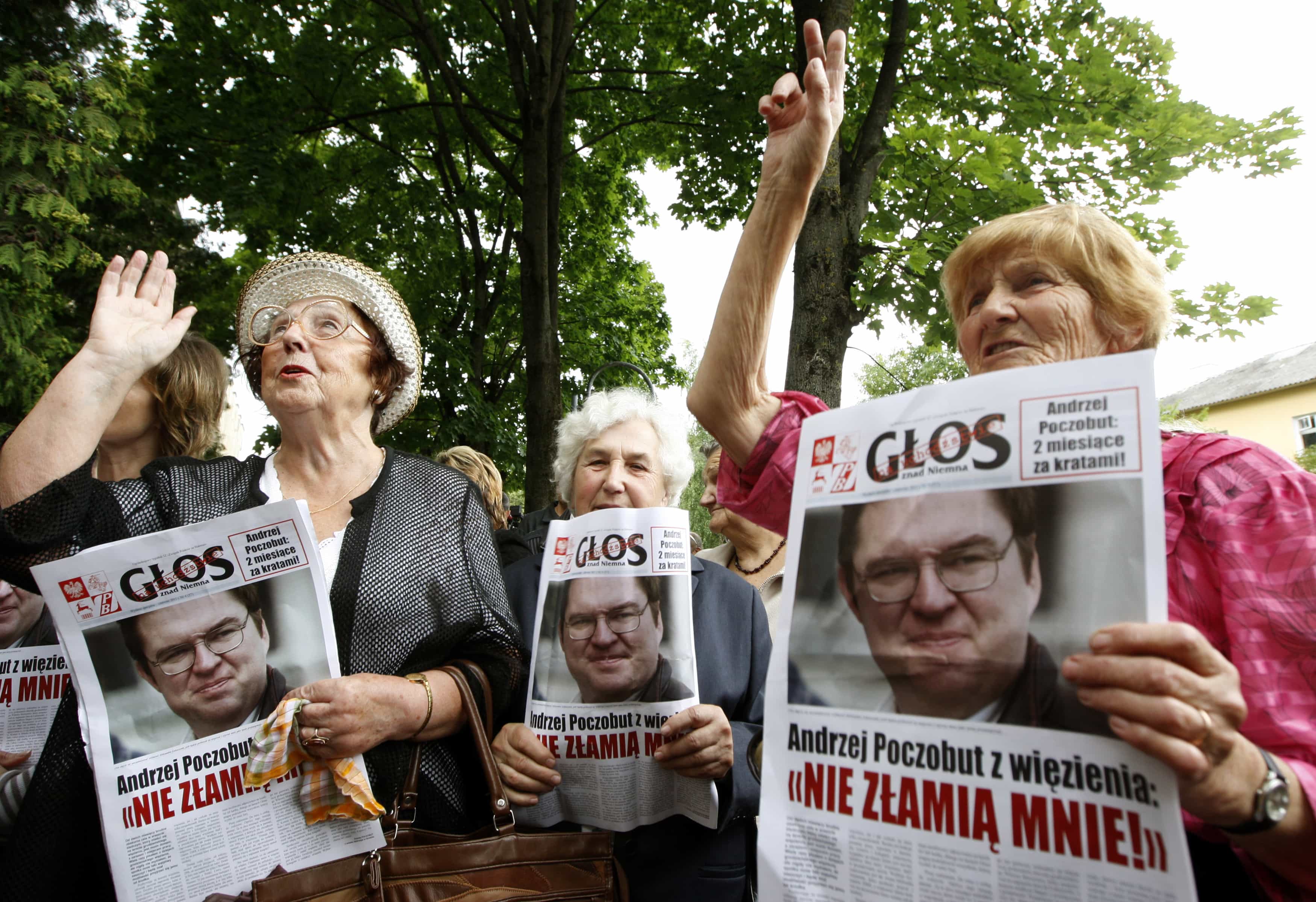 Supporters of Andrzej Poczobut hold copies of a newspaper displaying his portrait on 5 July 2011, REUTERS/Vasily Fedosenko