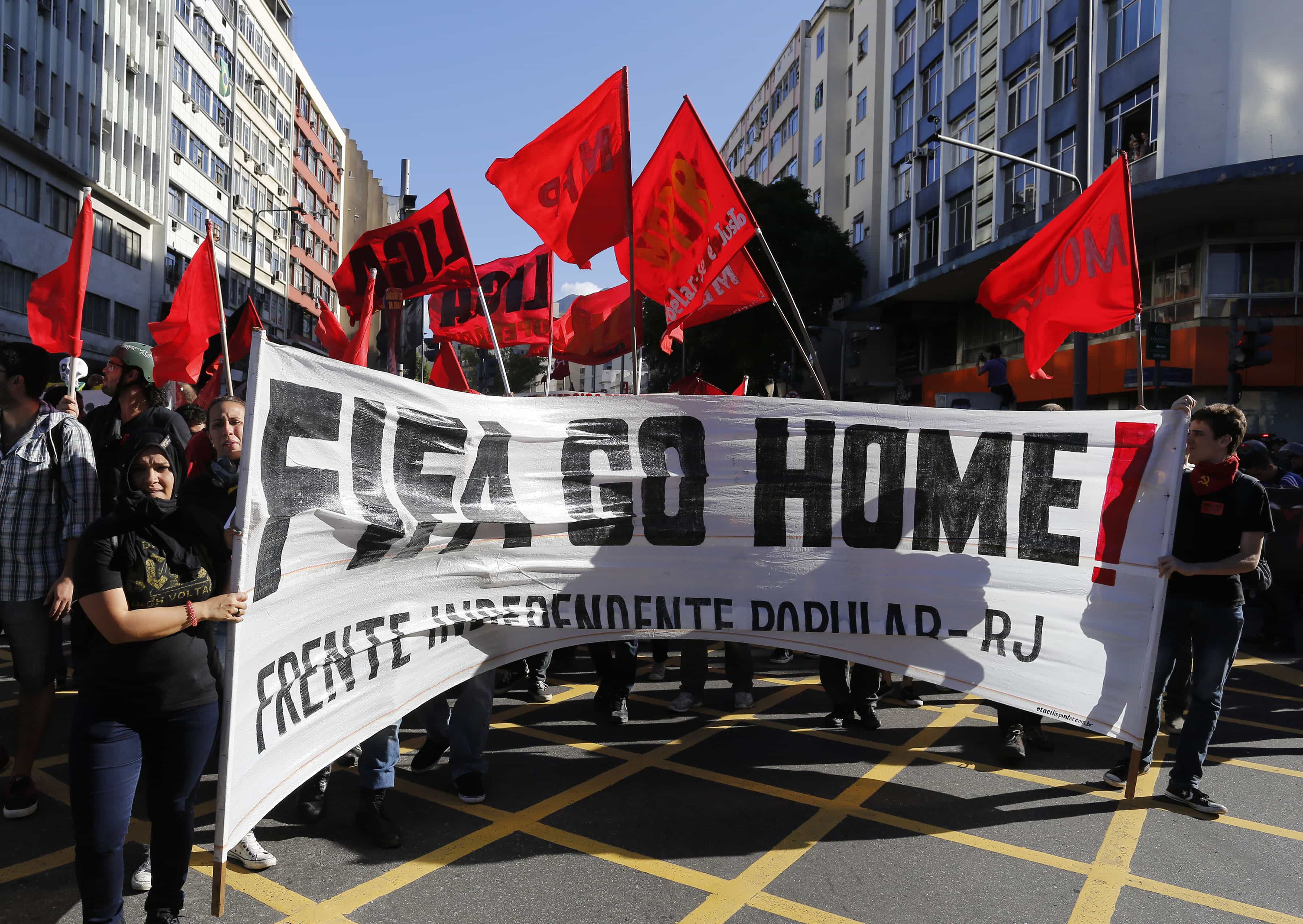 Anti-World Cup demonstrators hold a banner near Maracana stadium where the final game is taking place in Rio de Janeiro on 13 July 2014, AP Photo/Leo Correa