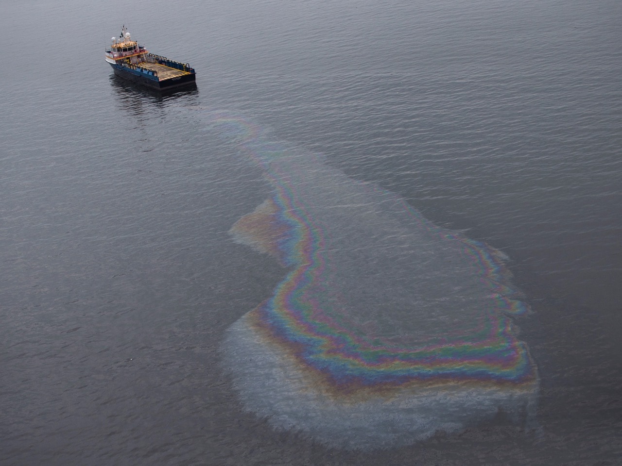 In this 23 March 2015 file photo, a boat leaks oil in the waters of Guanabara Bay in Rio de Janeiro, Brazil, AP Photo/Felipe Dana, File