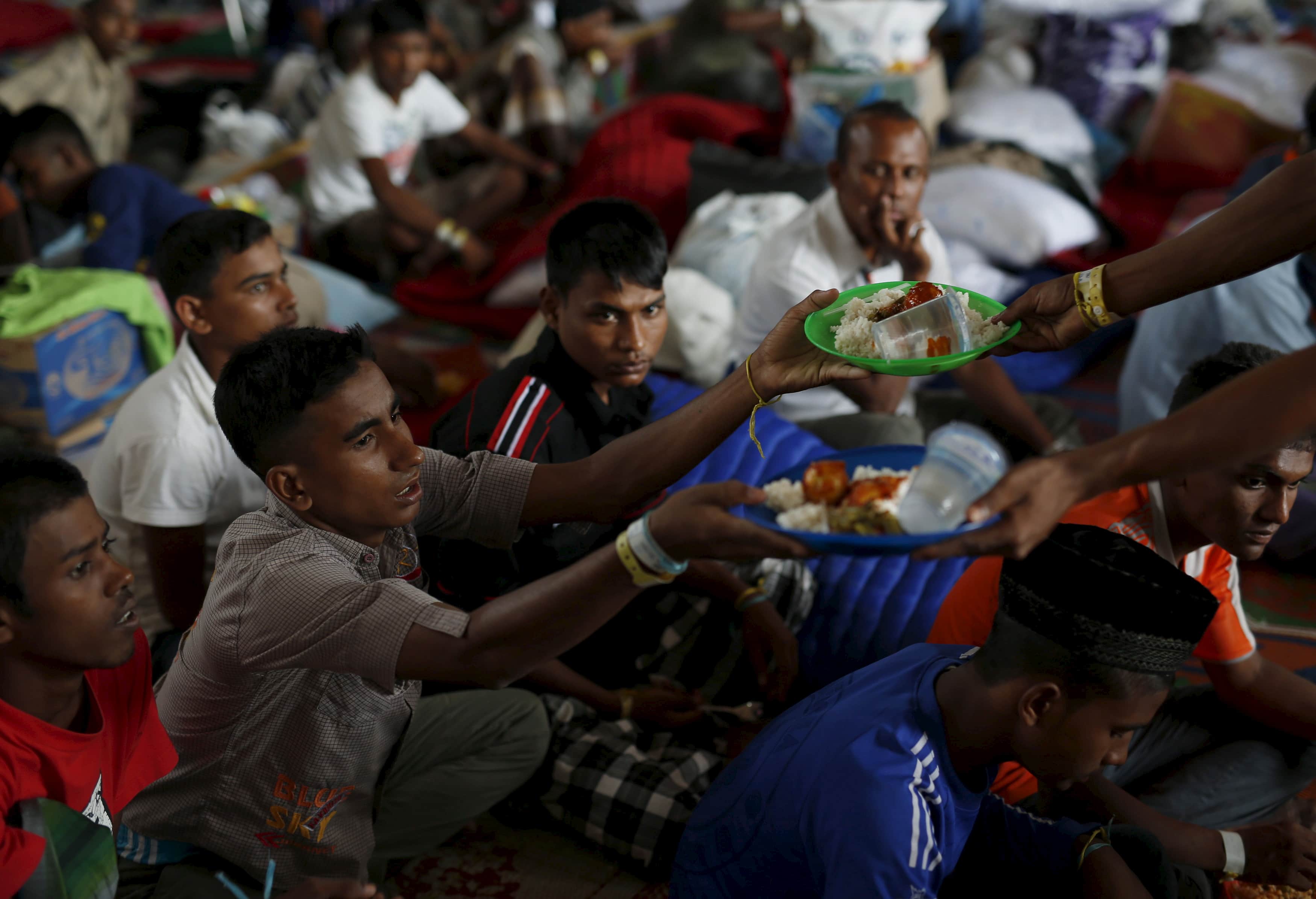 Rohingya migrants who arrived recently by boat receive their breakfast at a temporary shelter in Kuala Langsa, in Indonesia's Aceh Province, 25 May 2015, REUTERS/Darren Whiteside