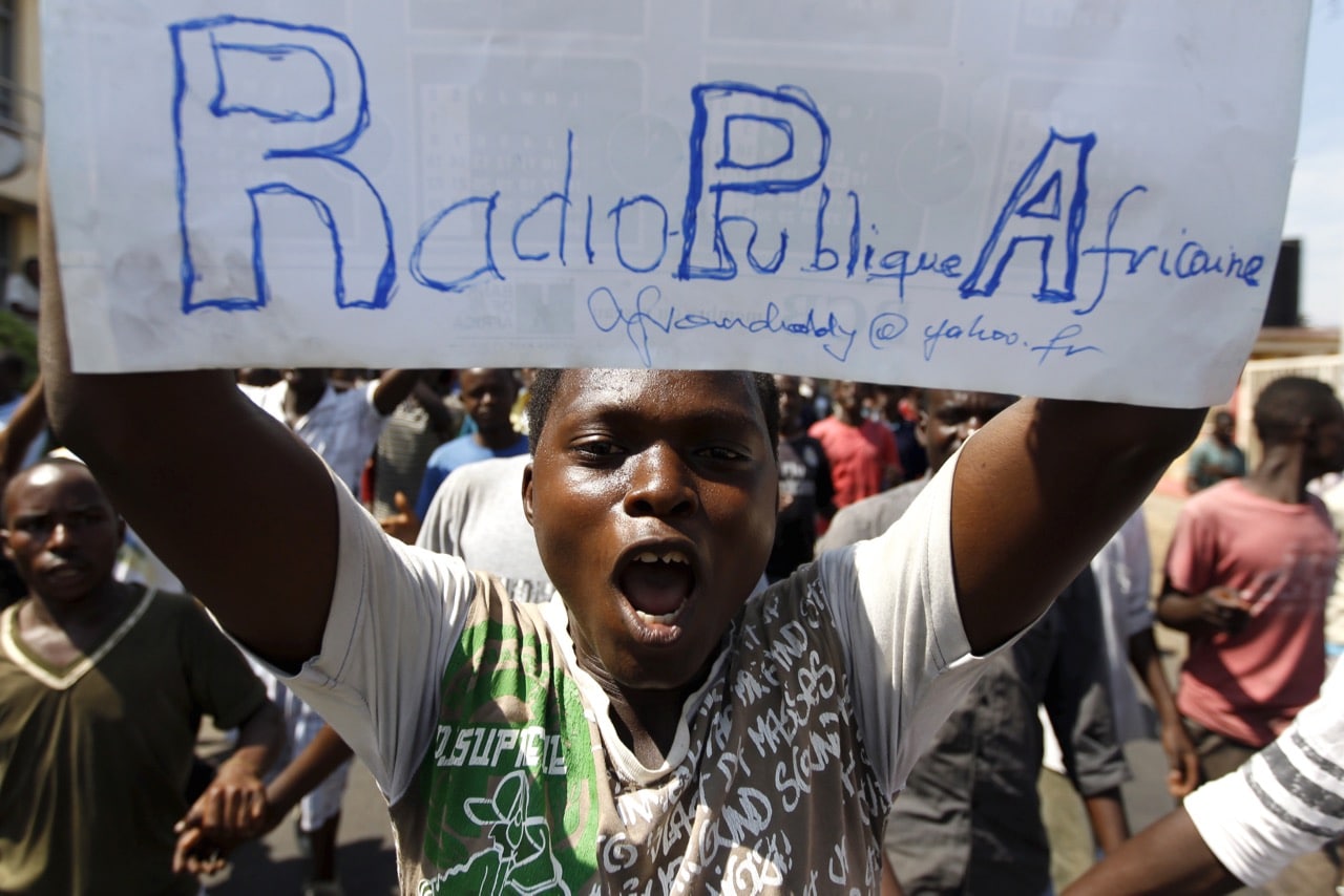 A protester carries a placard urging the government to re-open their local Radio Publique Africaine (RPA) in Burundi's capital Bujumbura, 29 April 2015, REUTERS/Thomas Mukoya