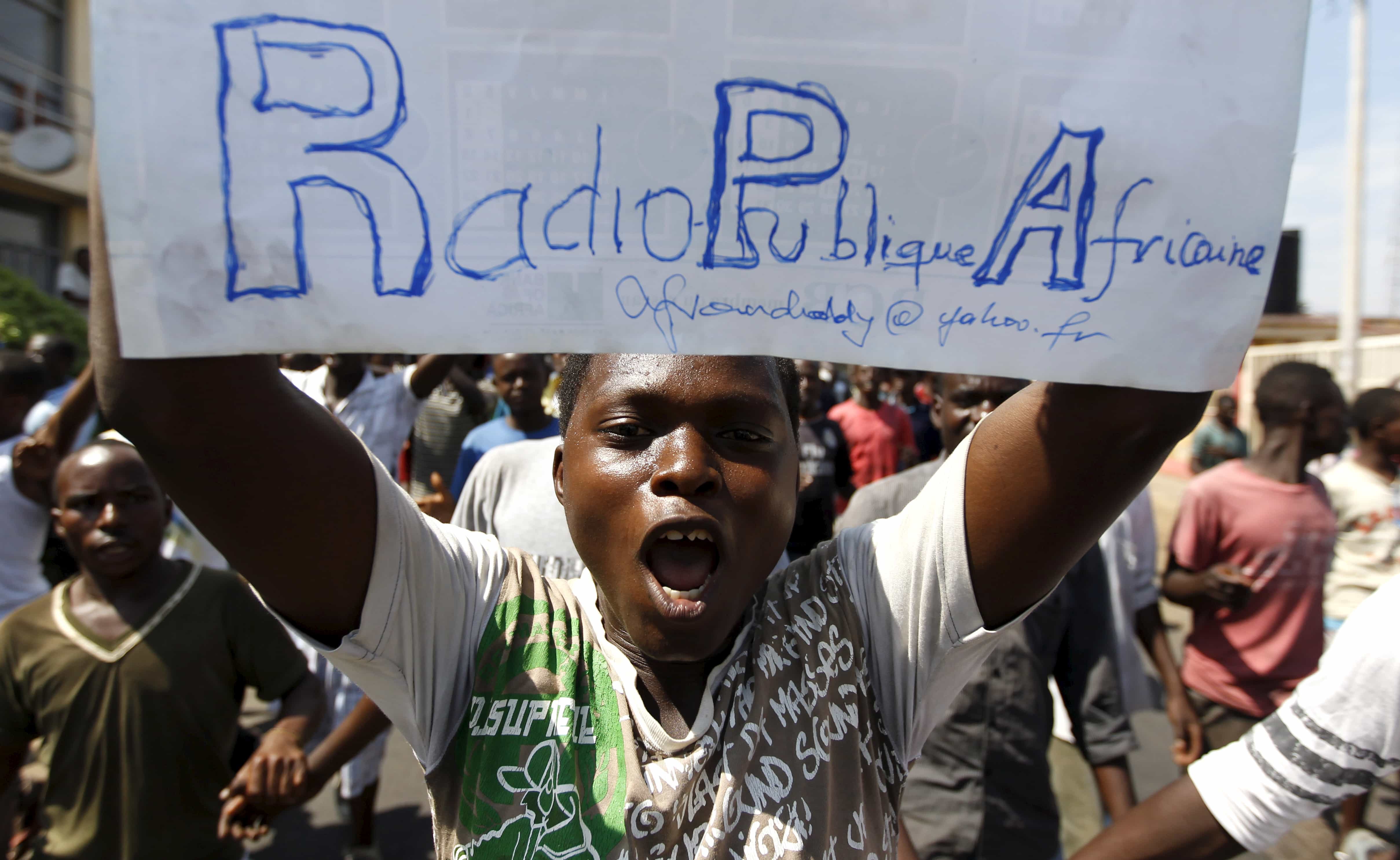 A protester carries a placard urging the government to re-open their local Radio Publique Africaine (RPA) in Burundi's capital Bujumbura, 29 April 2015, REUTERS/Thomas Mukoya