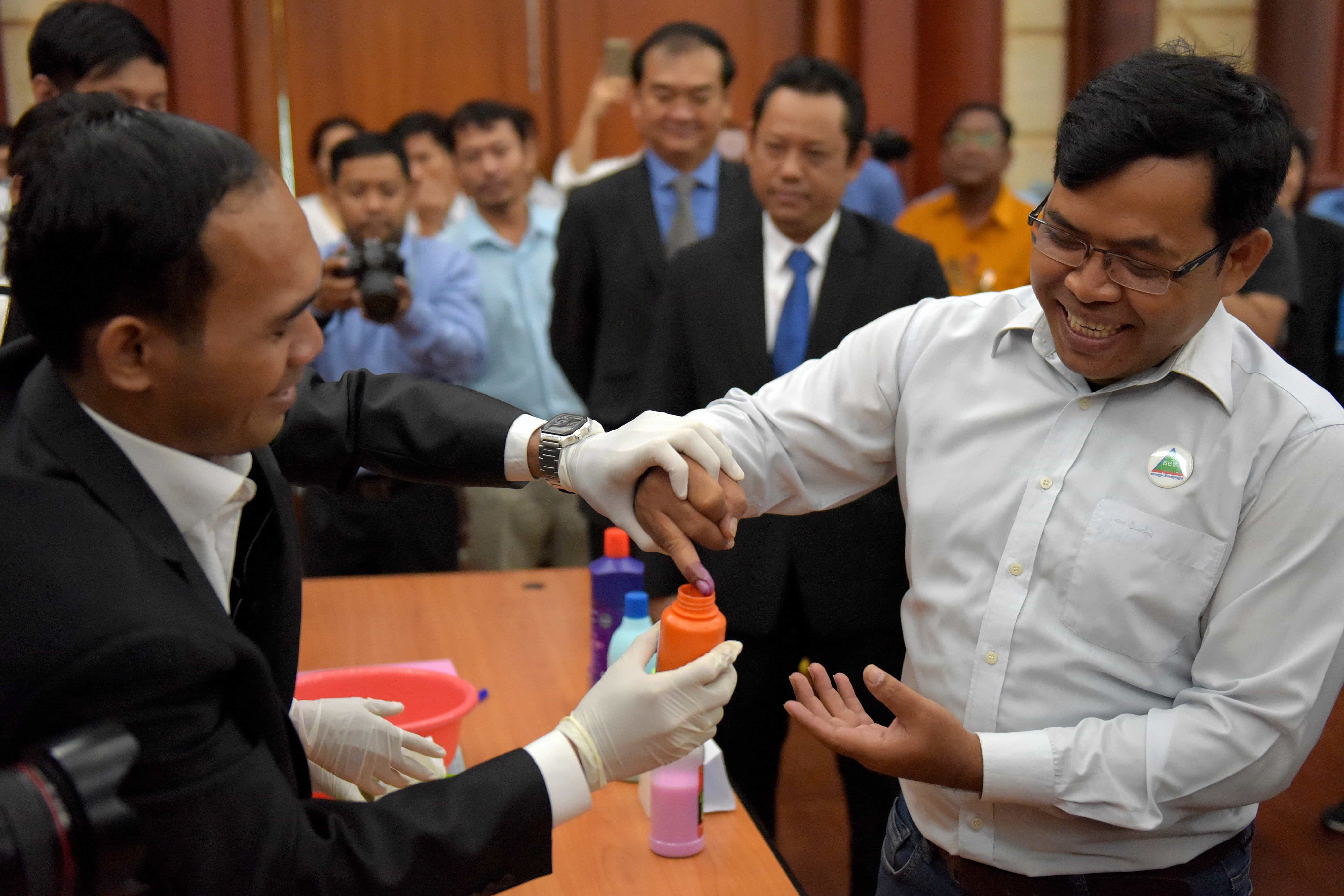 Cambodia's National Election Committee official uses a bottle of indelible ink to mark a finger during a briefing on the voting process in Phnom Penh on July 17, 2018, TANG CHHIN SOTHY/AFP/Getty Images
