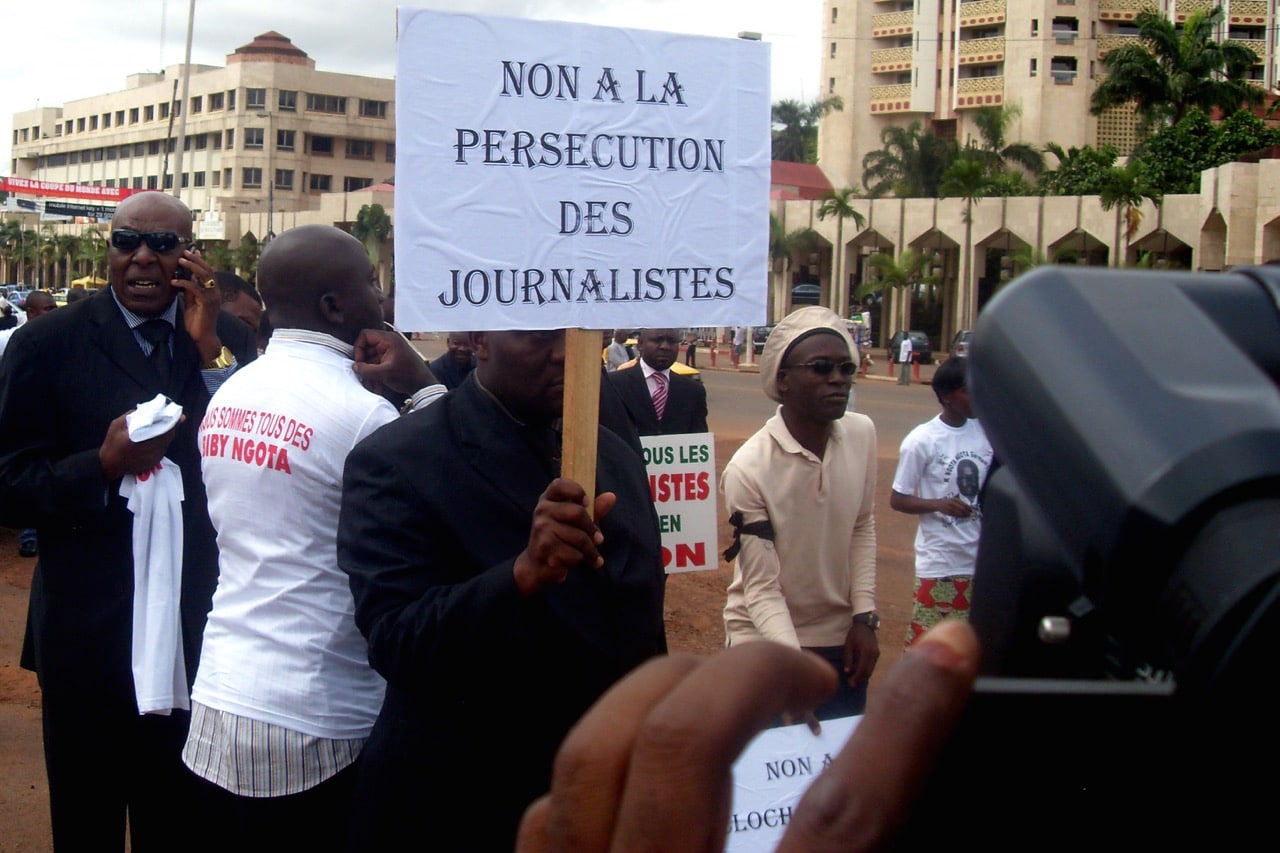 A Cameroonian journalist holds a banner raeding 'No to the persecution of journalists' during a rally in Yaoundé, 3 May 2010, Reinnier KAZE/AFP/Getty Images