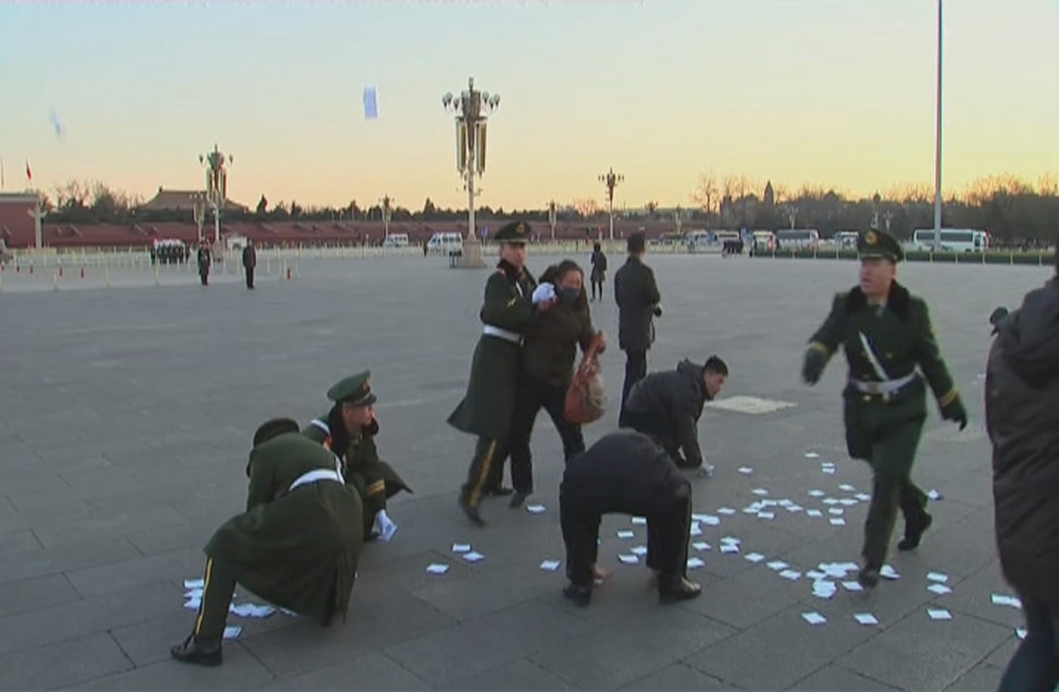 A video grab shows a protester being restrained, as paramilitary officers pick up leaflets during a protest in Tiananmen Square in Beijing, before the opening of the National People's Congress, 5 March 2014, REUTERS/Reuters TV