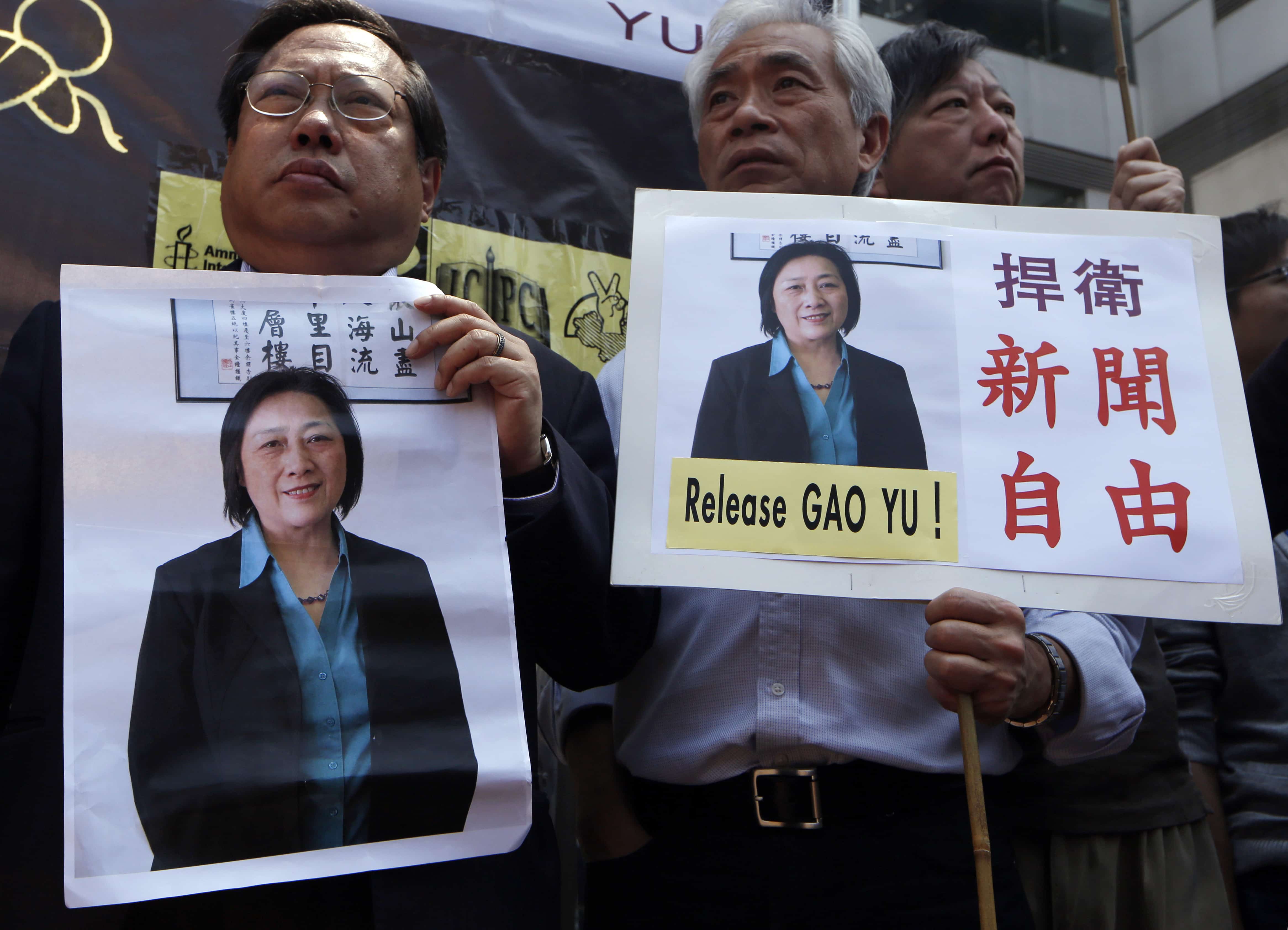 Anti-Beijing protesters hold pictures of jailed veteran Chinese journalist Gao Yu during a rally outside Chinese central government's liaison office in Hong Kong Friday, April 17, 2015 as they demand press freedom and the release of Gao, AP Photo/Kin Cheung