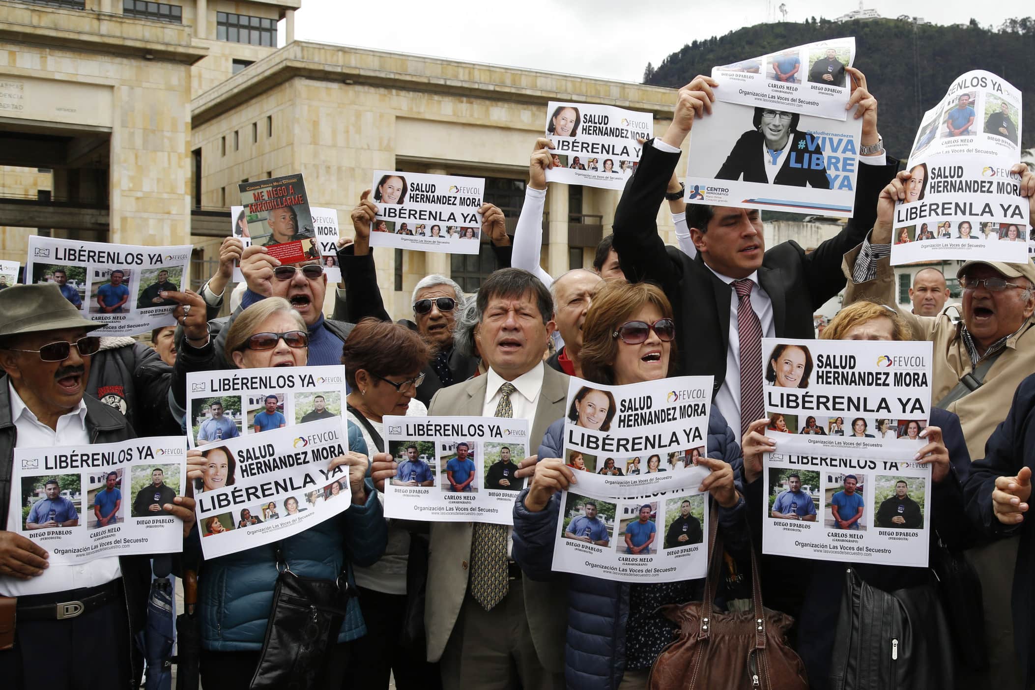 Demonstrators hold signs to demand the release of three journalists who are believed to have been taken hostage in Colombia, 25 May 25 2016, AP Photo/Fernando Vergara