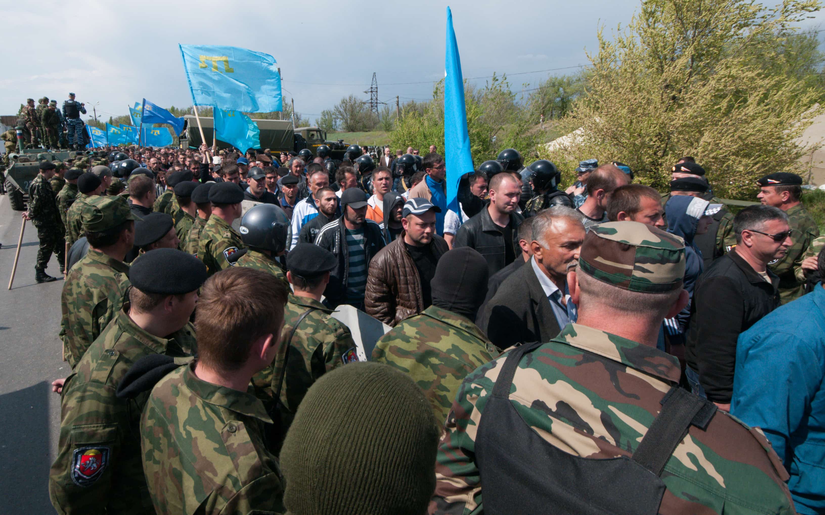 Crimean Tatars walk at a blocked road at a Russian-Ukrainian border check point outside the town of Armyansk, Crimea, 3 May 2014, AP Photo/Alexander Polegenko