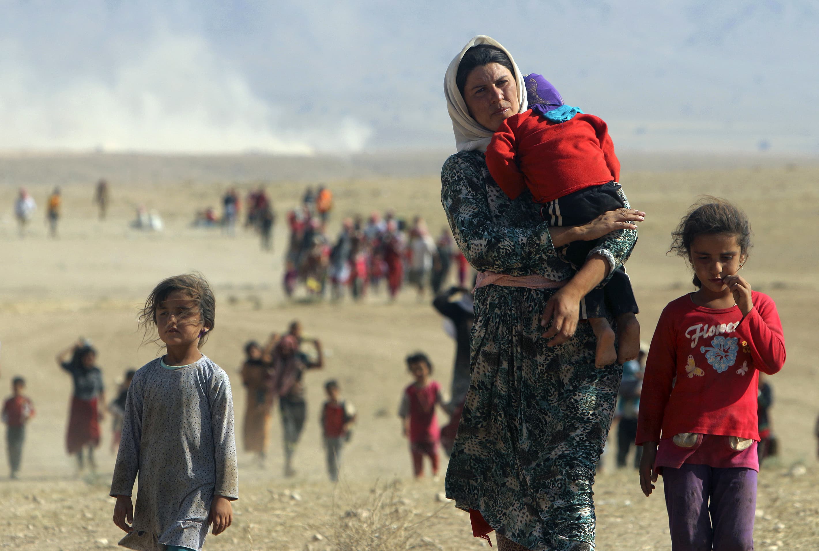 Displaced people from the Yezidi sect, fleeing violence from forces linked to the ISIS in the Iraqi town of Sinjar, walk towards the Syrian border in August 2014, REUTERS/Rodi Said