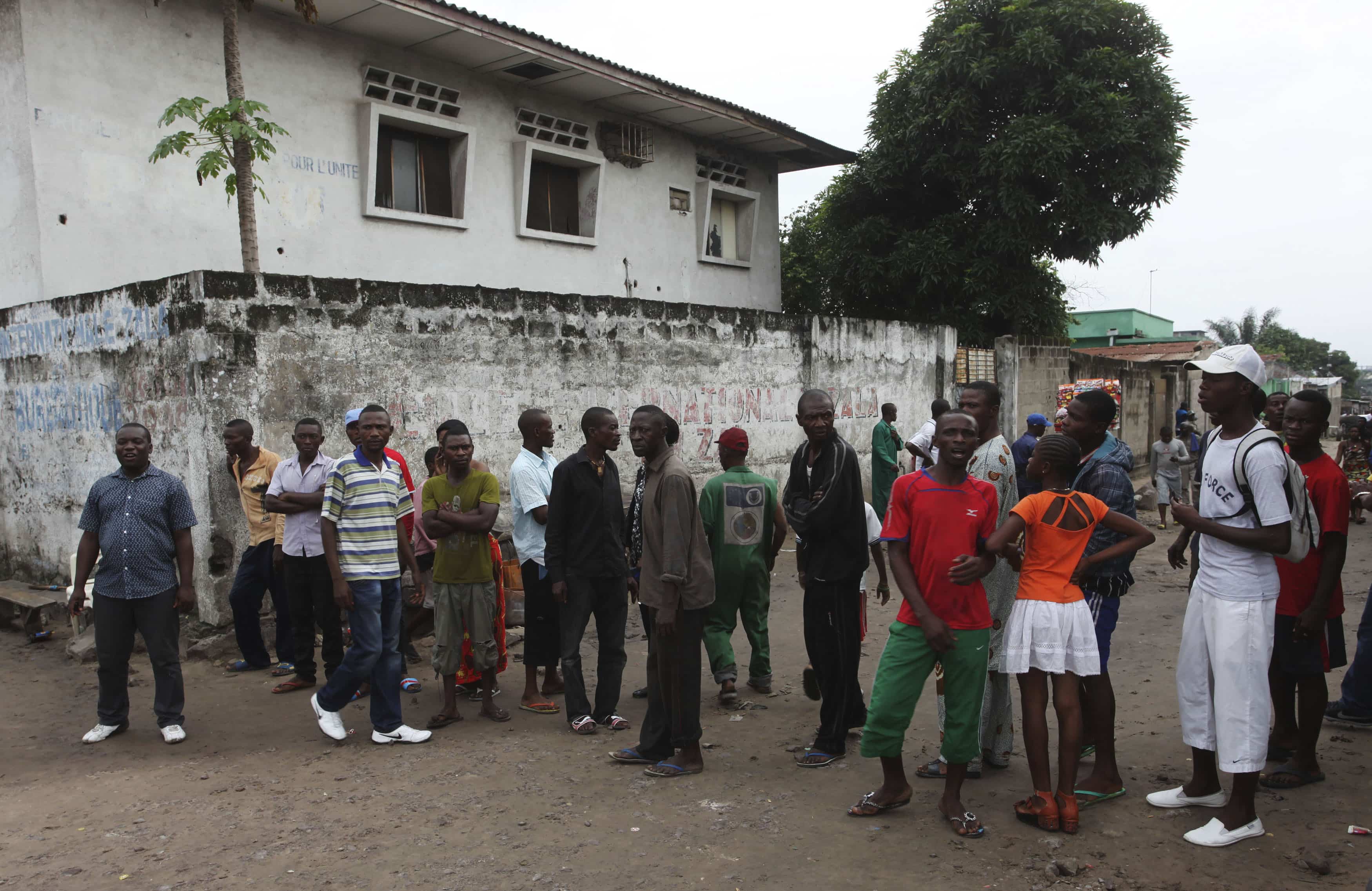 Residents gather to watch as security forces patrol the street near the state television headquarters in Kinshasa, 30 December, 2013., REUTERS/Jean Robert N'Kengo