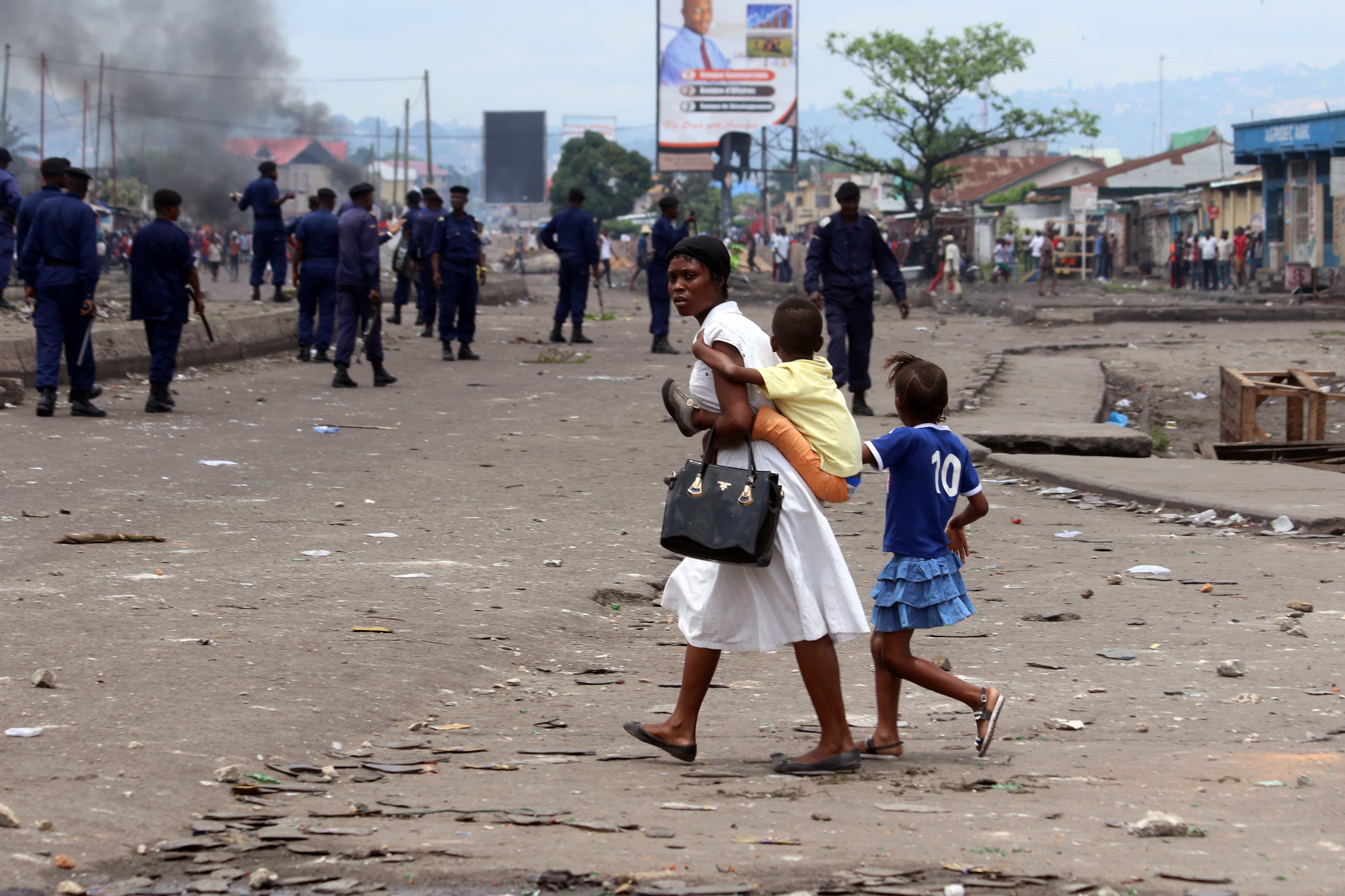 A family pass near Congolese riot police during a protest in Kinshasa, 19 September 2016, AP Photo/John Bompengo