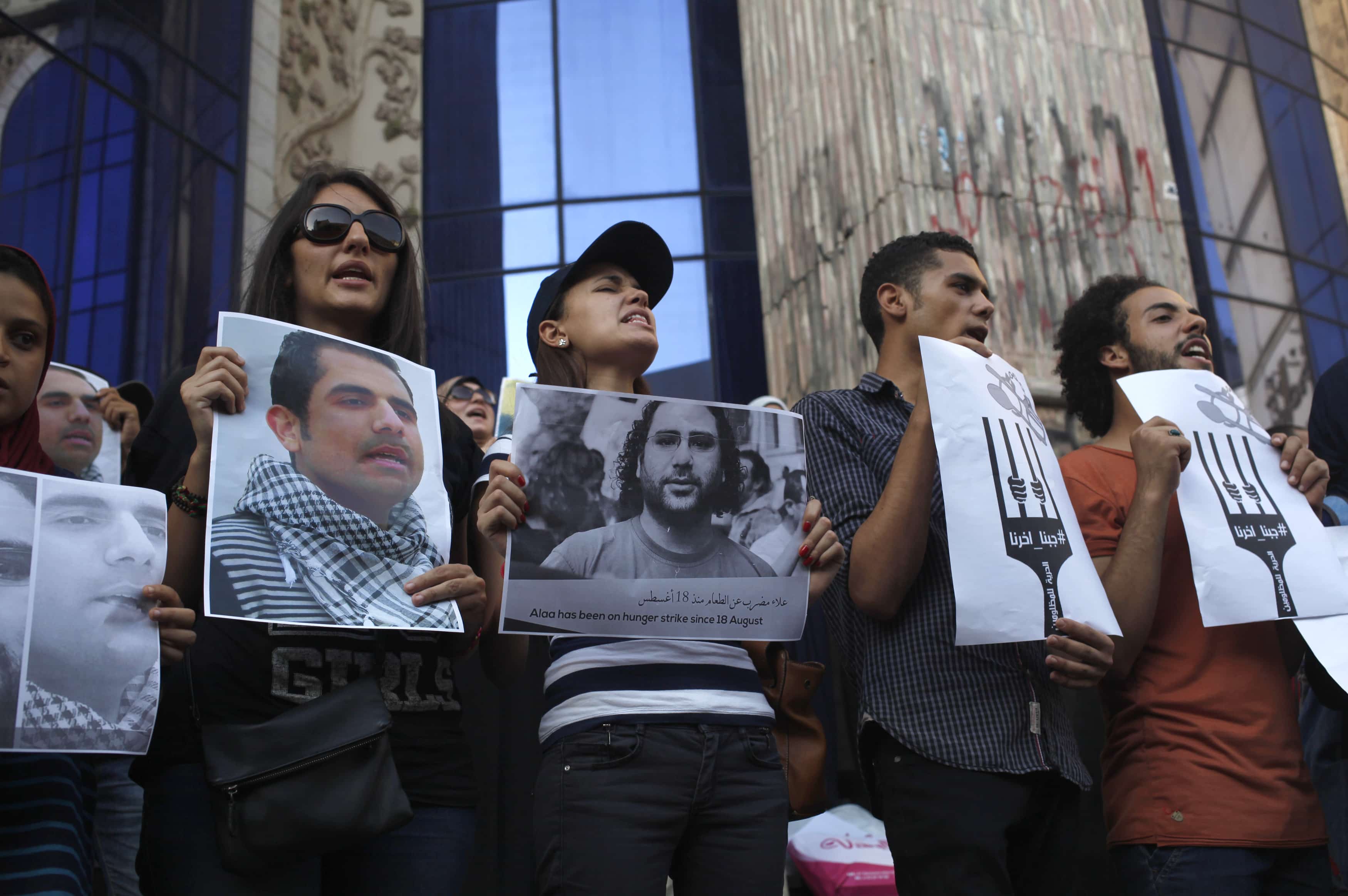 Protesters hold pictures during a protest in support of imprisoned activists who are in a hunger strike at prison, in front of the Press Syndicate, in Cairo on 25 August 2014, REUTERS/Asmaa Waguih