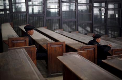 Policemen sit in front of empty bars during a verdict hearing in Egypt (11 April 2015), REUTERS/Amr Abdallah Dalsh