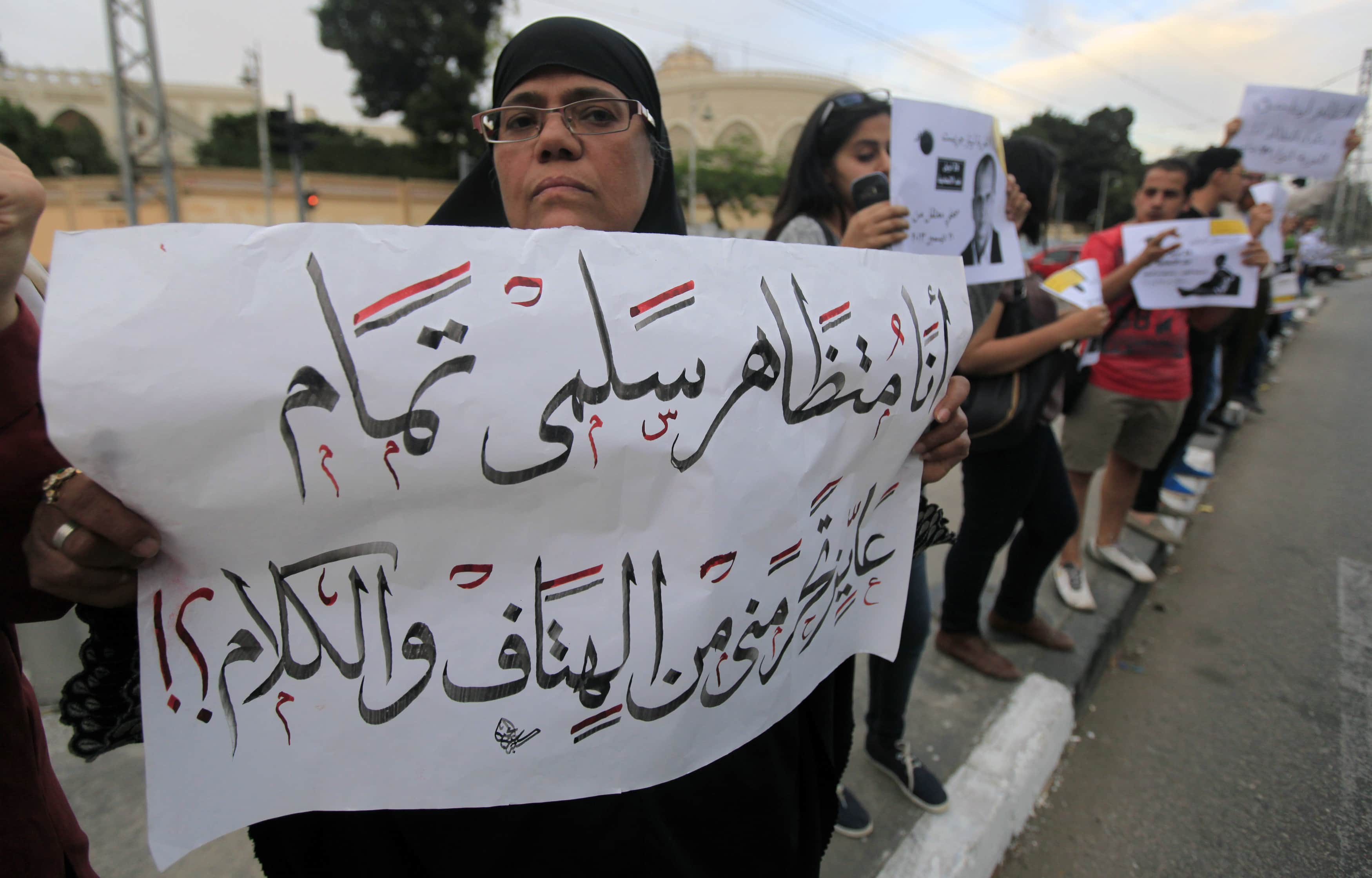 Activists form a human chain against a law restricting protests in Cairo on 23 April 2014. The sign reads: "I am a peaceful protester. Why stop me from speaking out.", REUTERS/Amr Abdallah Dalsh