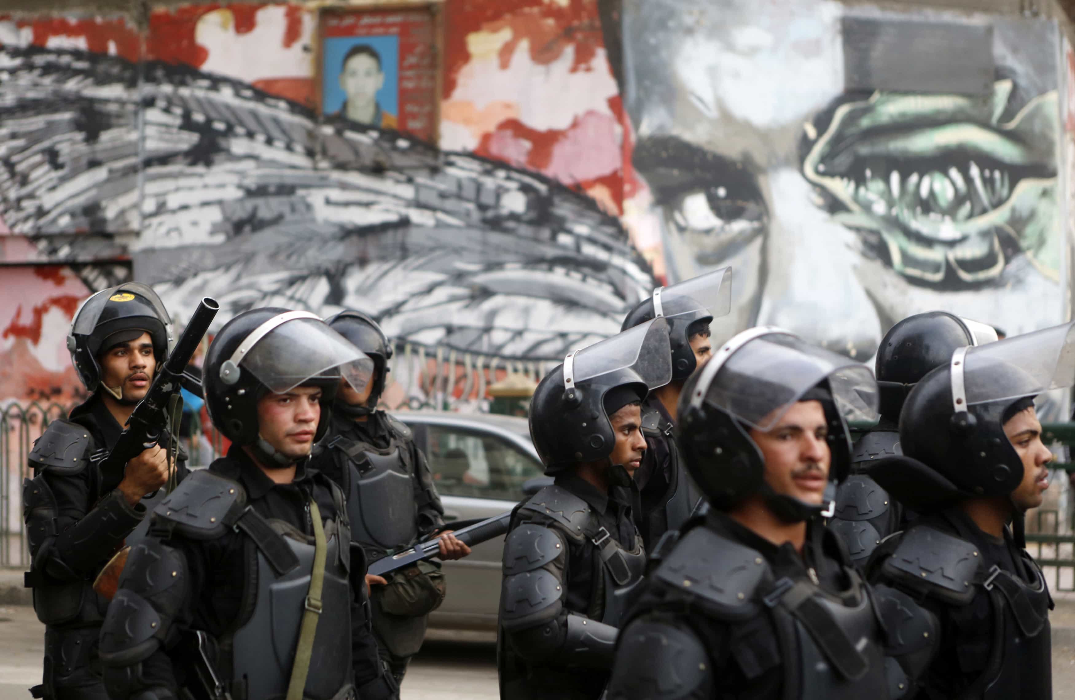 Riot police walk in front of graffiti in Cairo, 19 November 2014,  REUTERS/Amr Abdallah Dalsh