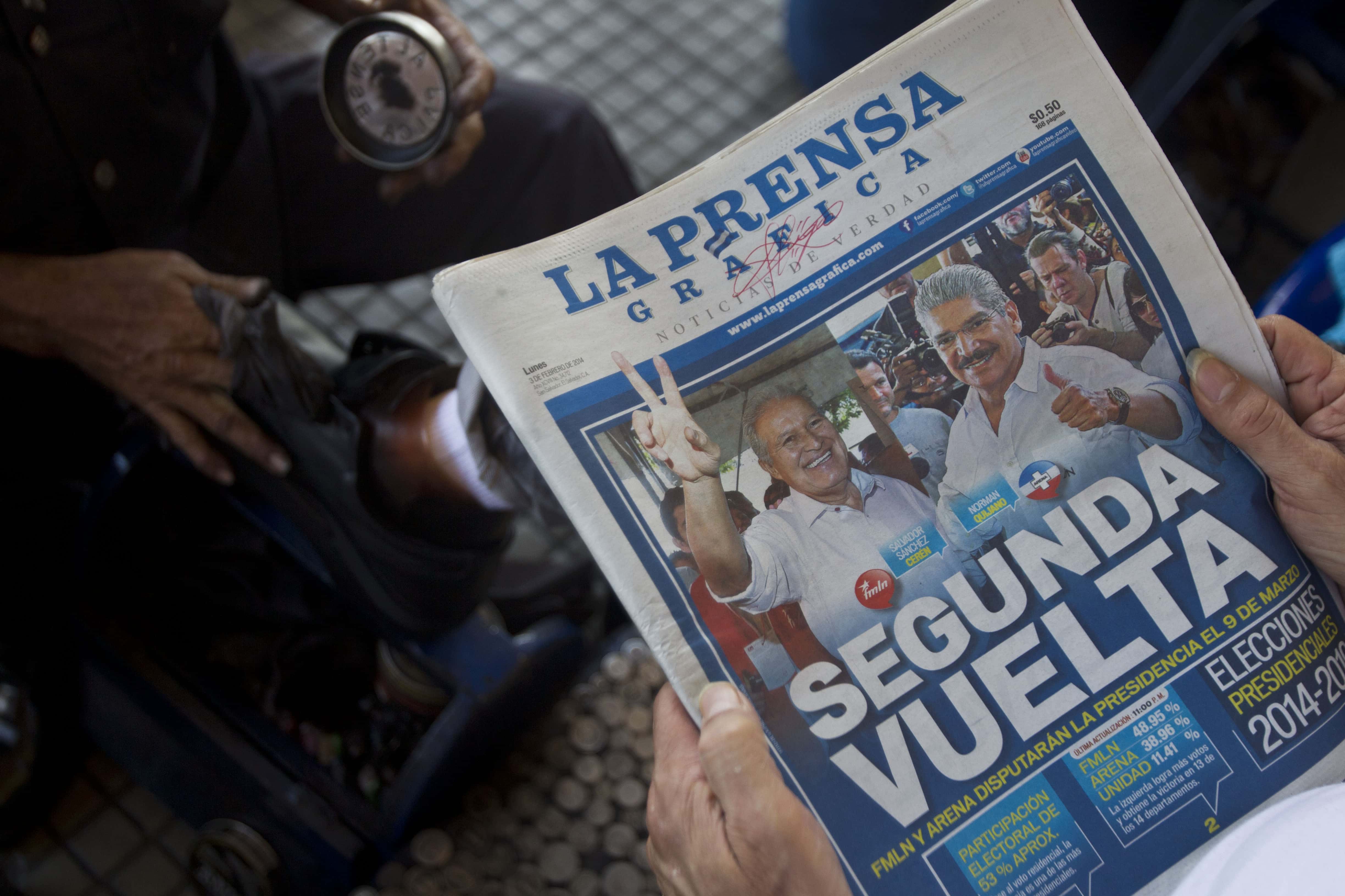 A man reads a copy of "La Prensa Gráfica" while having his shoes shined in San Salvador, El Salvador, 3 February 2014, AP Photo/Esteban Felix