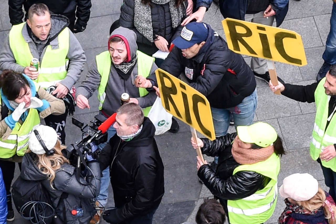 Journalists are heckled by "Yellow vest" (gilets jaunes) anti-government demonstrators, two holding signs that read RIC, the acronym for 'Citizens Initiated Referendum' during a protest in Bordeaux, France, 29 December 2018, MEHDI FEDOUACH/AFP/Getty Images