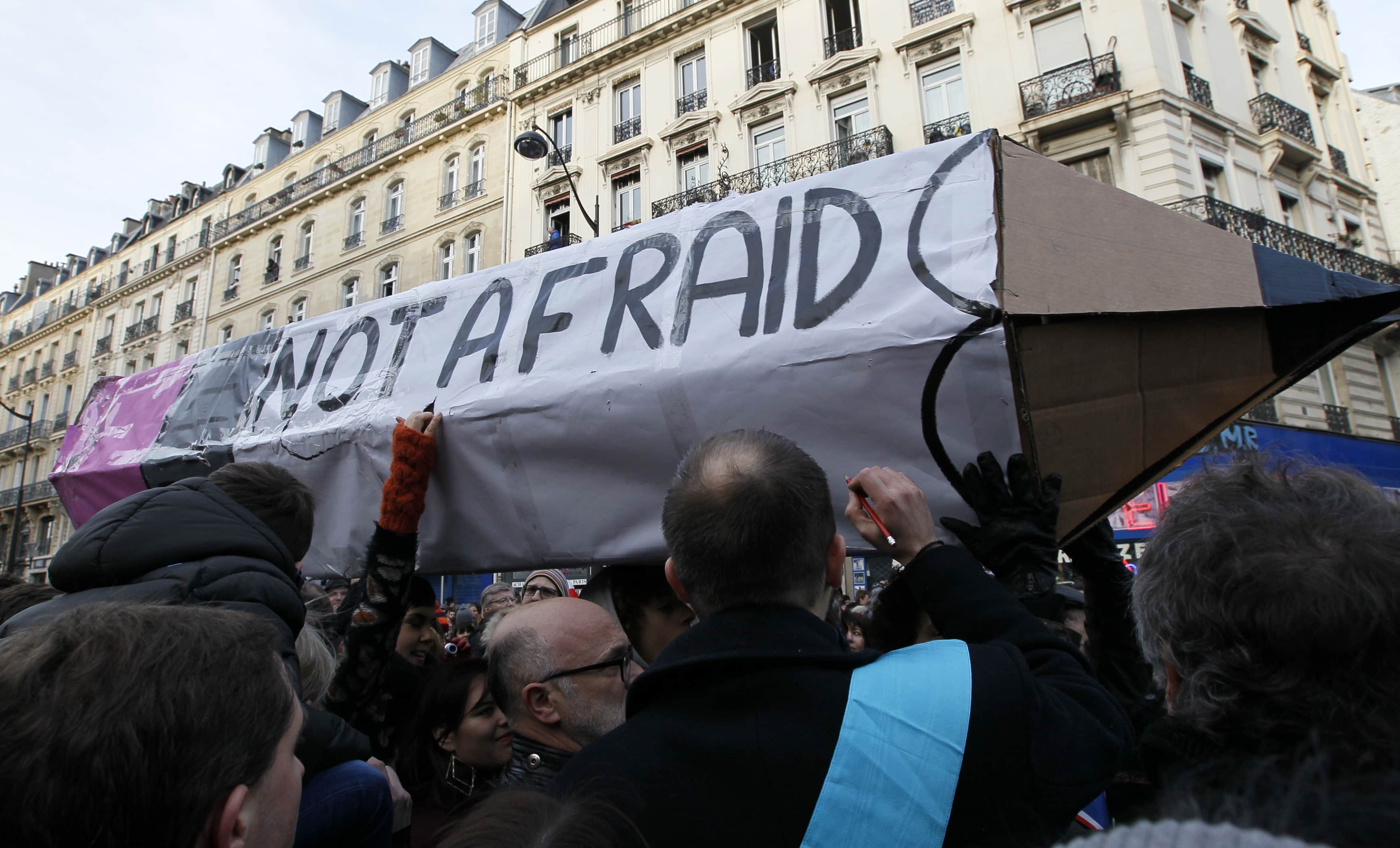 Protesters carrying a giant cardboard pencil reading "Not Afraid" take part in a solidarity march in the streets of Paris January 11, 2015, REUTERS/Youssef Boudlal