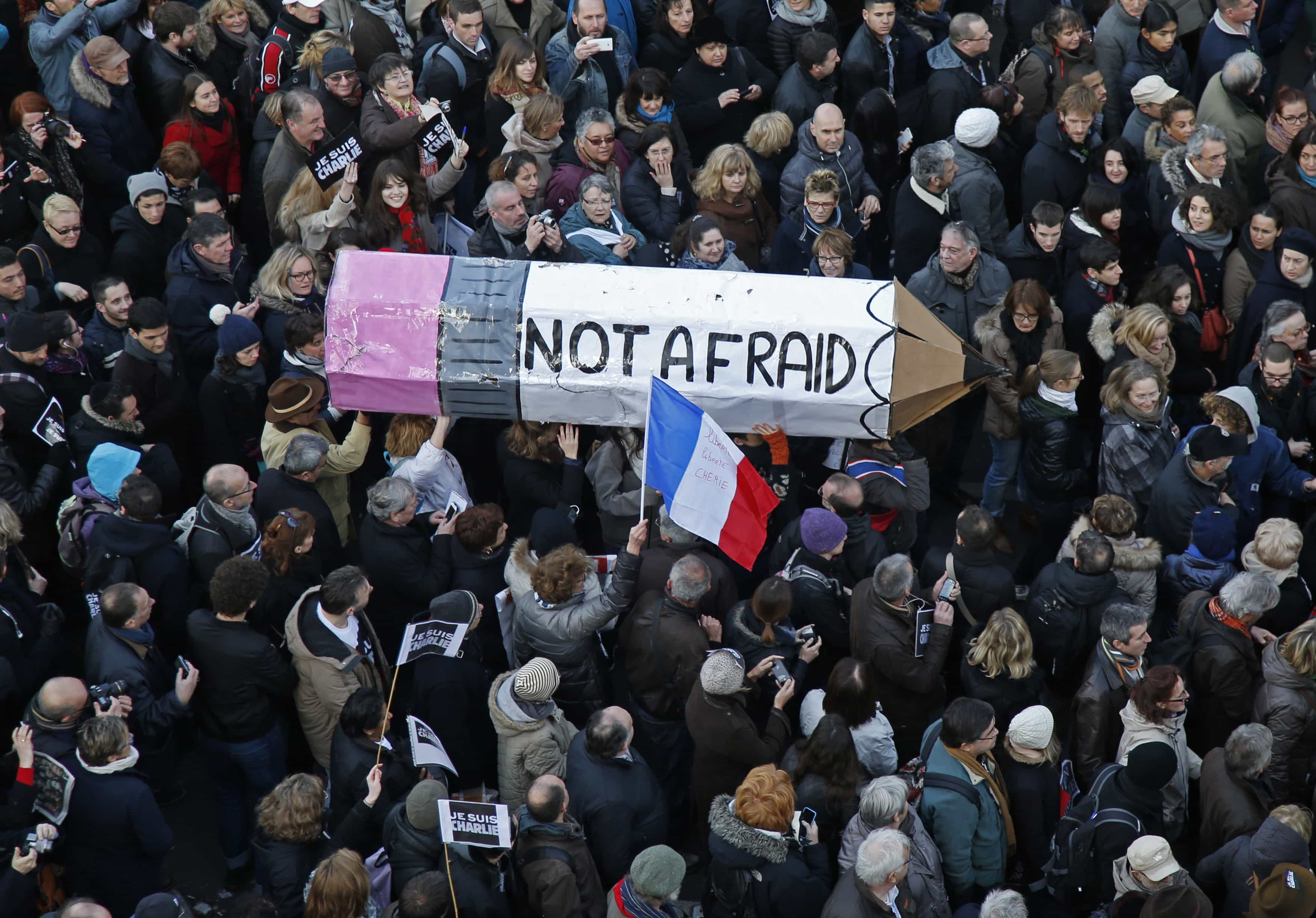 Citizens carrying a giant cardboard pencil reading "Not Afraid" take part in a Hundreds of thousands of French citizens solidarity march (Marche Republicaine) in the streets of Paris January 11, 2015. , REUTERS/Charles Platiau.