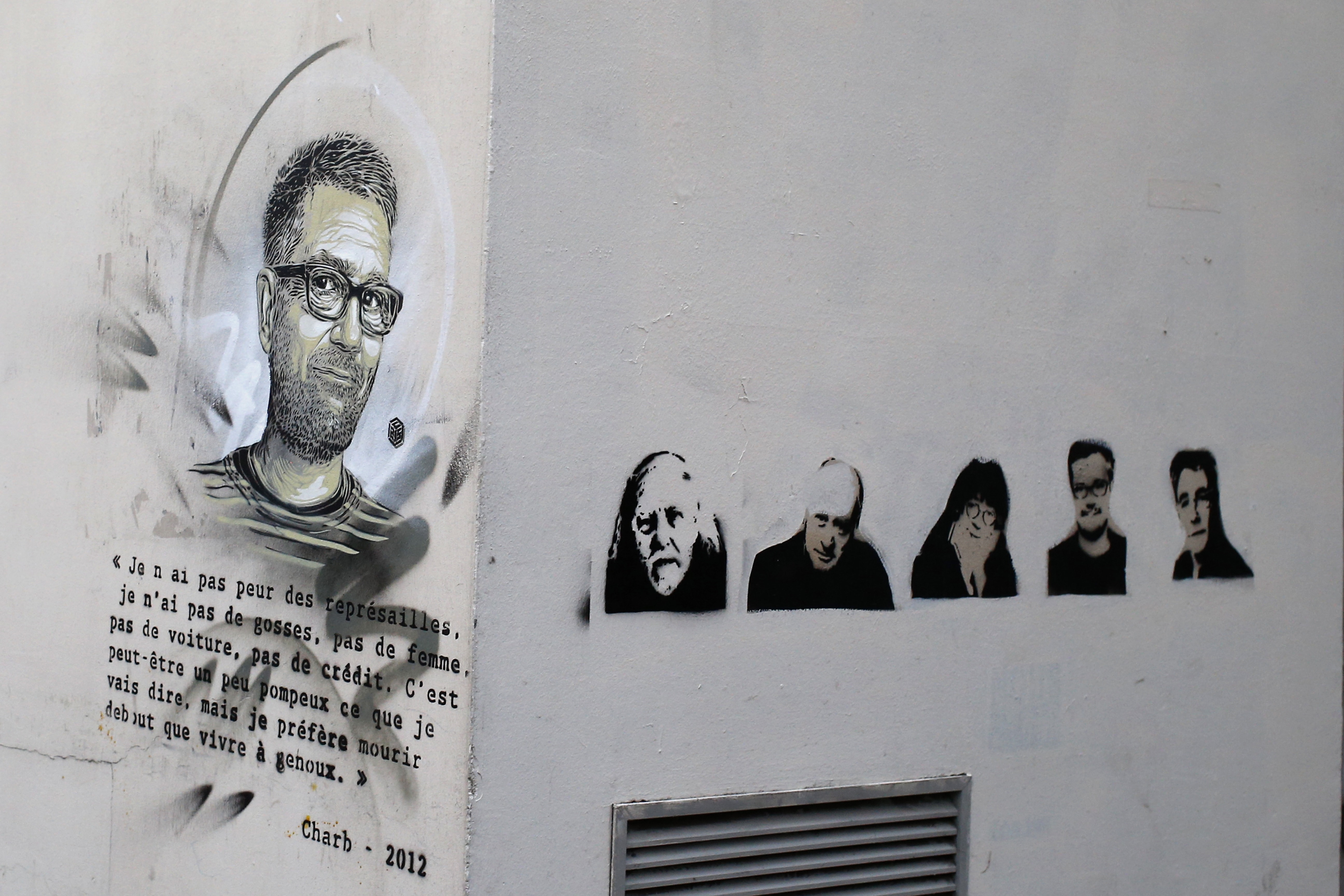 A painting of killed cartoonists is seen on a wall outside Charlie Hebdo's former office in Paris, 7 January 2016, AP Photo/Francois Mori