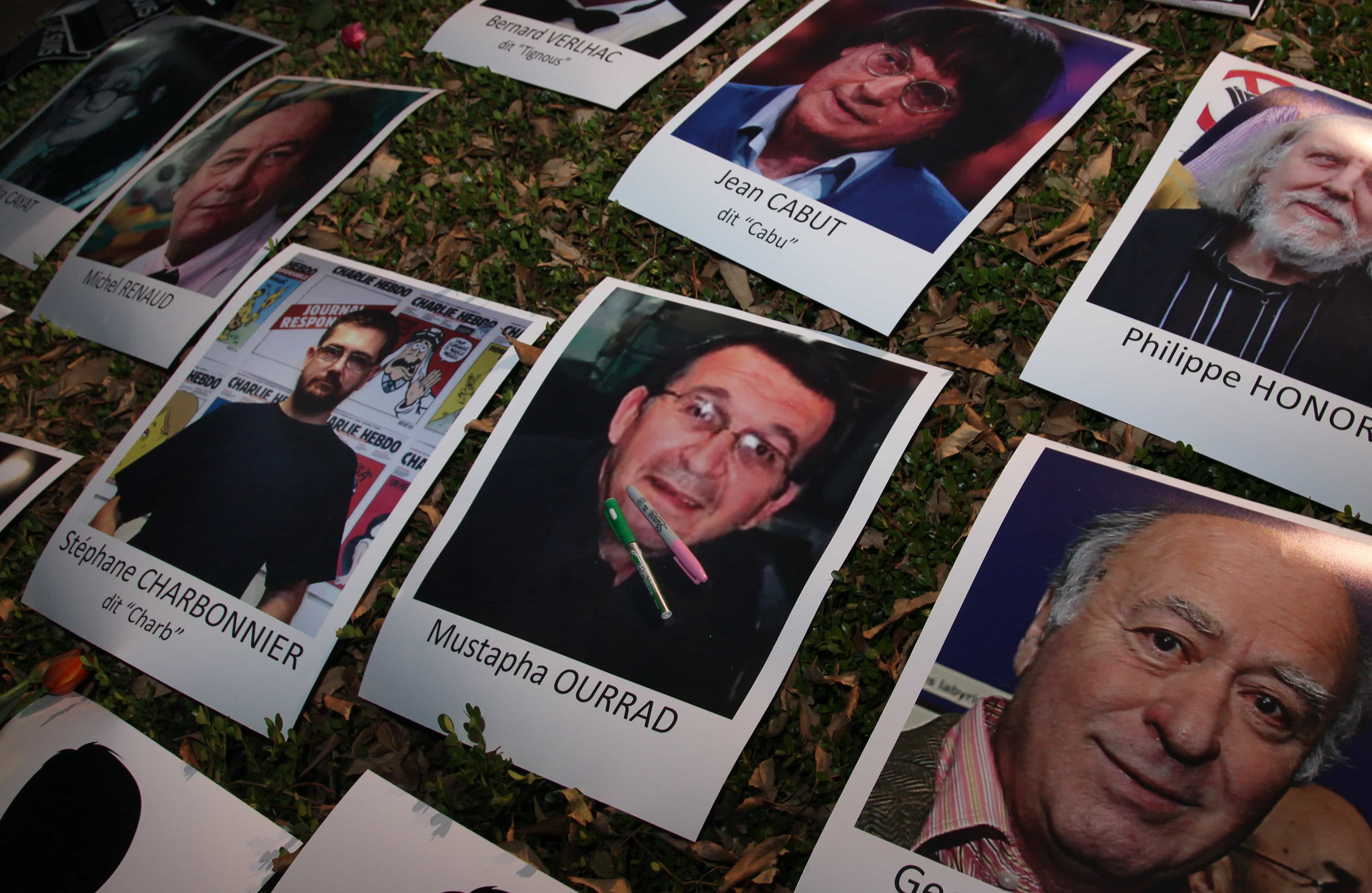 Photographs of slain journalists from the Paris newspaper Charlie Hebdo lay during a vigil outside France's embassy in Mexico City, 8 January 2015, AP Photo/Marco Ugarte